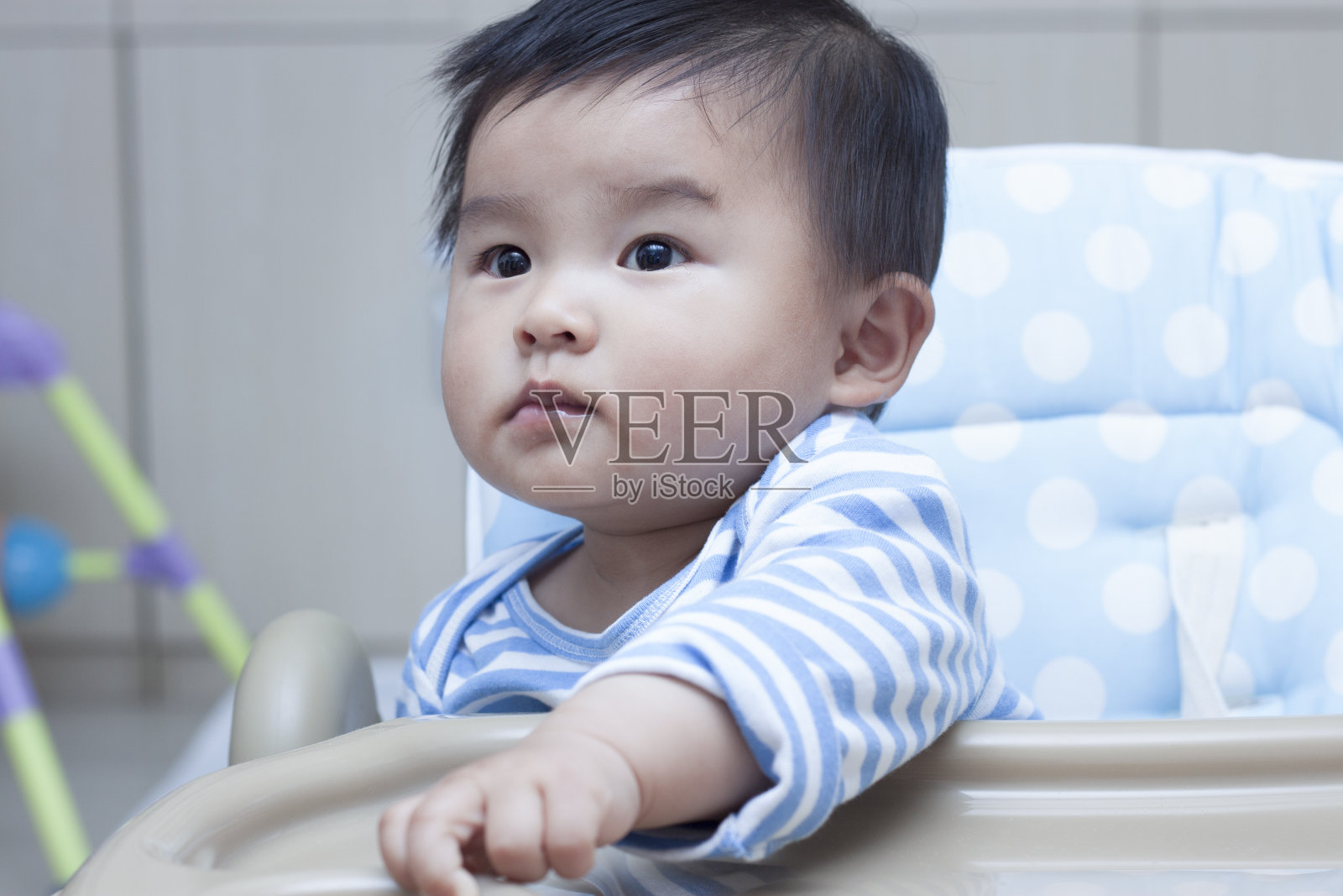 可爱的中国男婴坐在婴儿椅上照片摄影图片