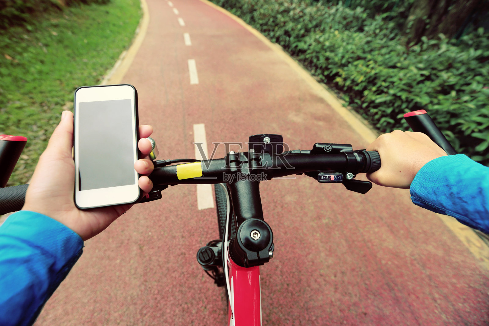 使用智能手机应用导航，在森林里骑自行车。照片摄影图片