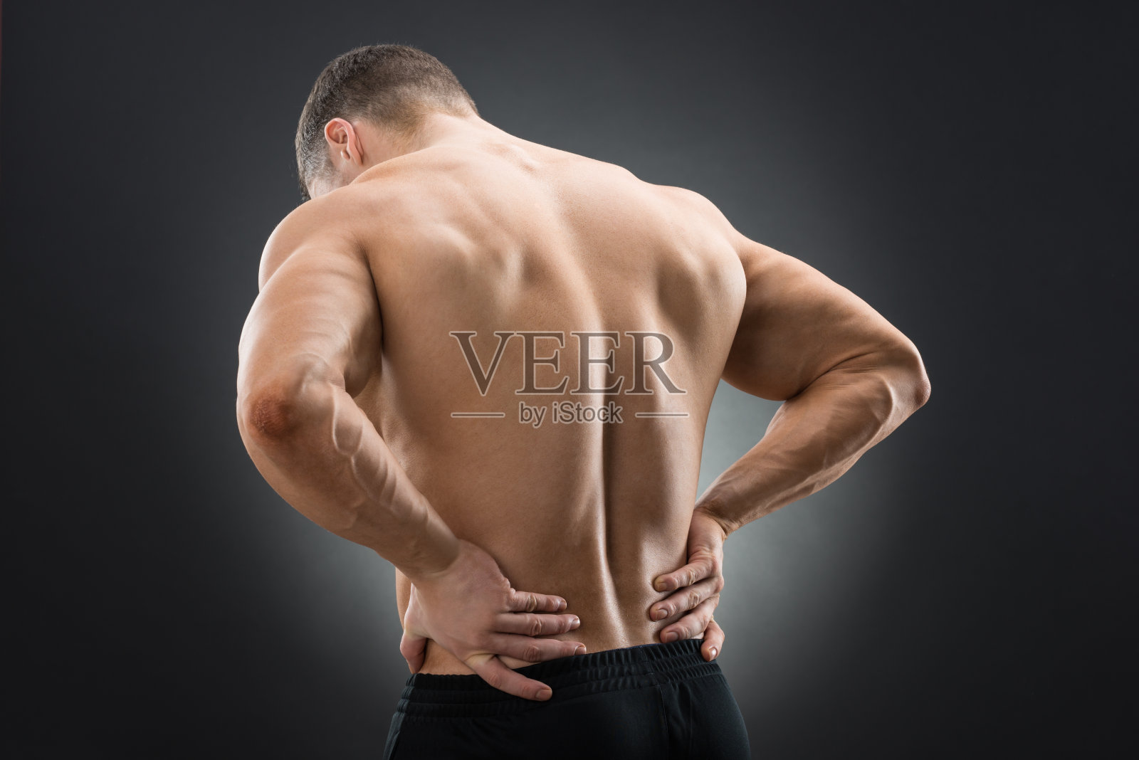 背部疼痛的肌肉男的后视图照片摄影图片