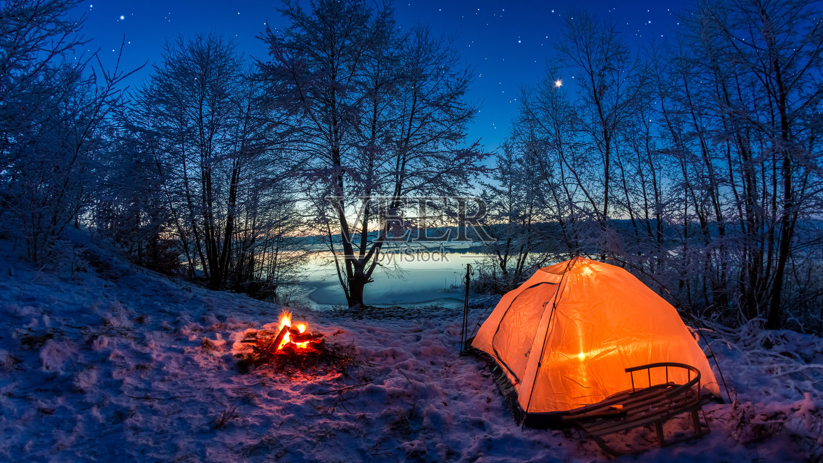黄昏时分，白雪覆盖的冬湖上的日出照片摄影图片