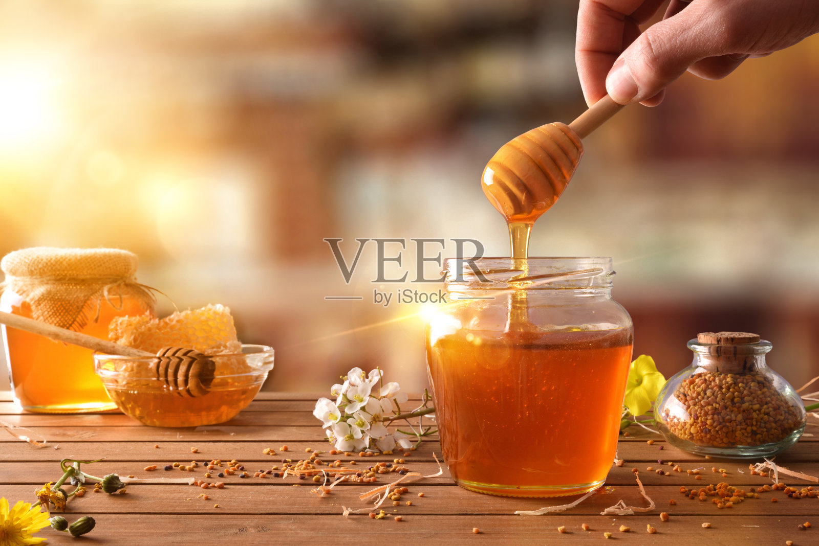 用勺子从一罐蜂蜜中取出蜂蜜照片摄影图片