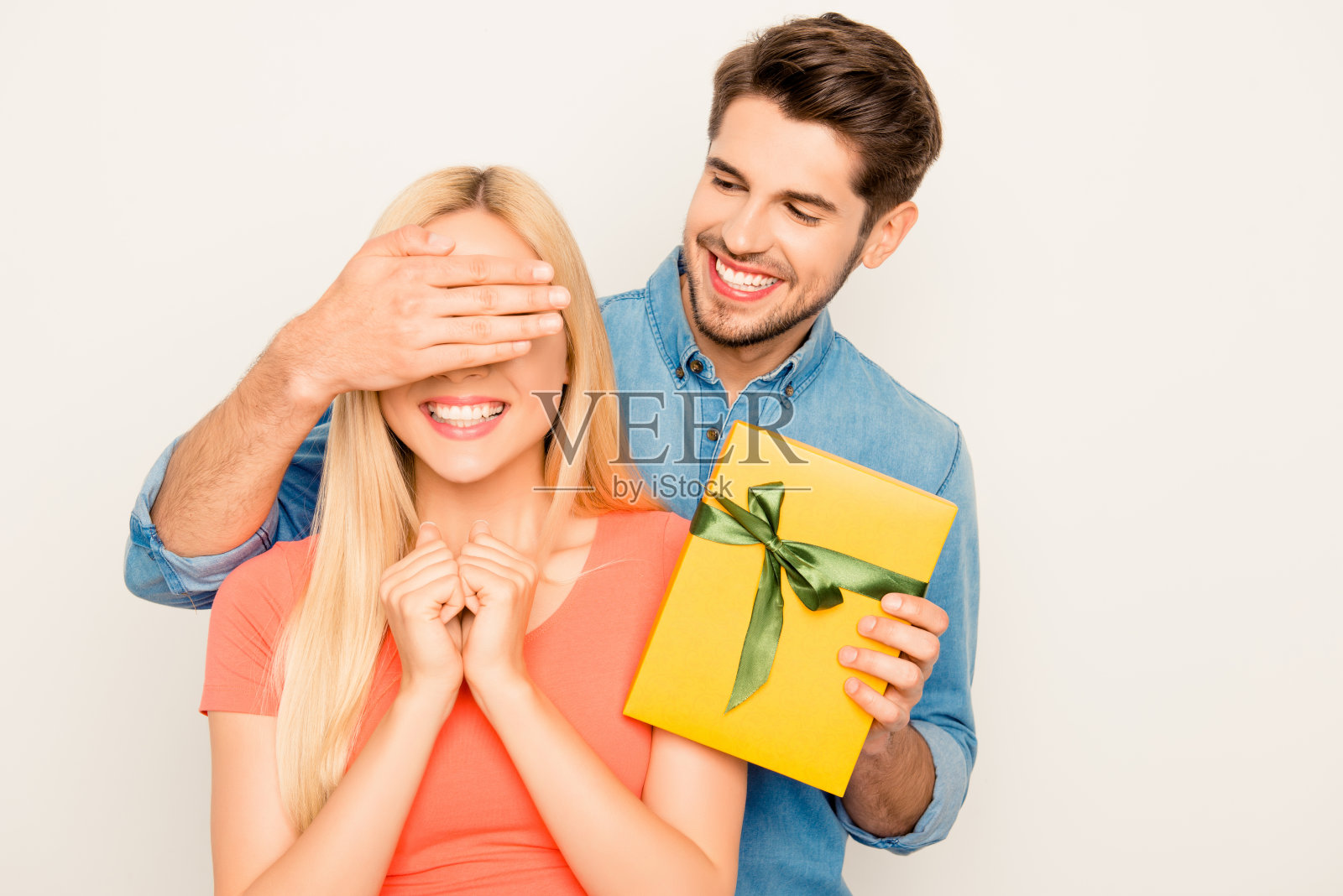 幸福的男人闭着眼睛看着他的妻子，拿着礼物照片摄影图片