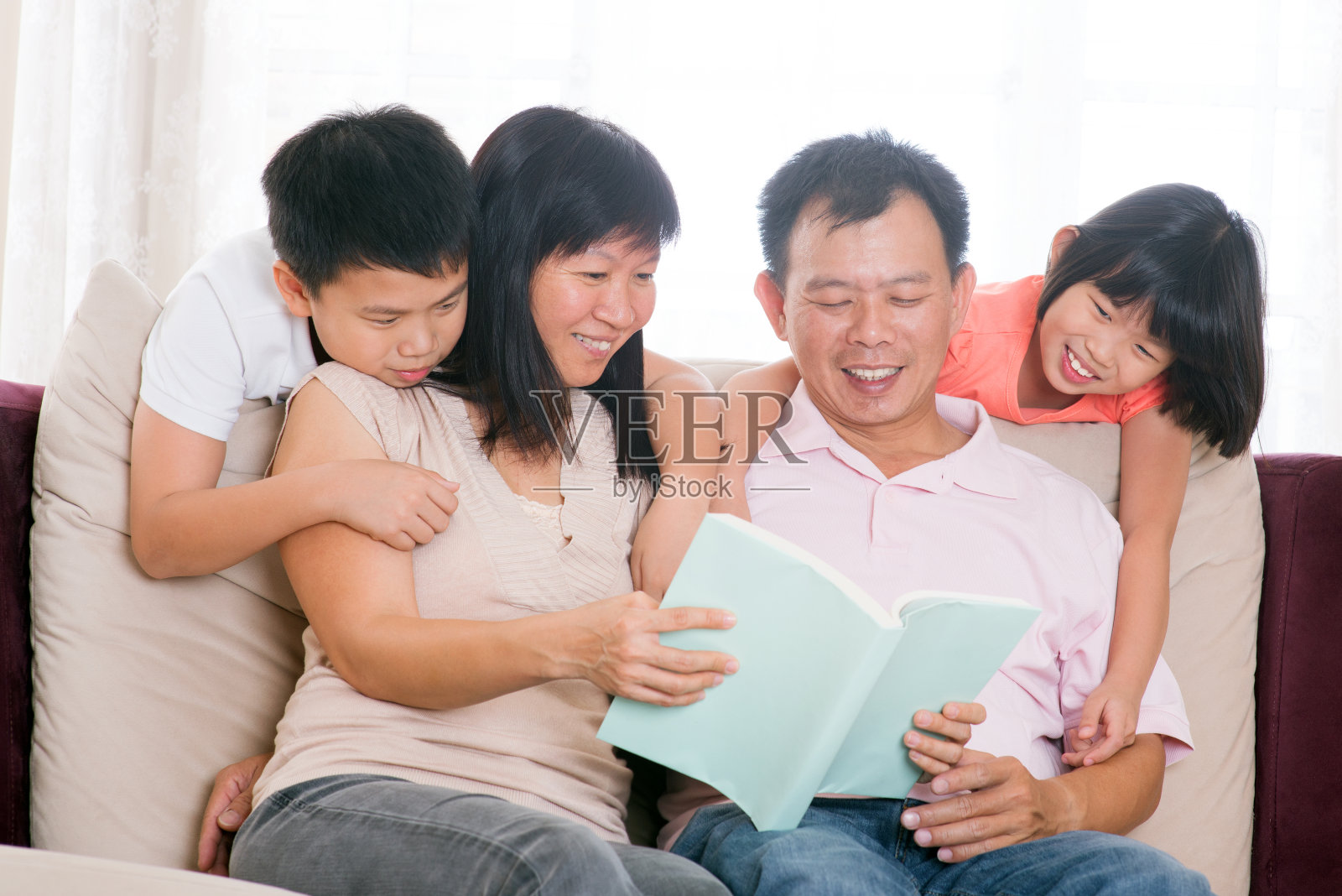 父母和孩子在家看书。照片摄影图片