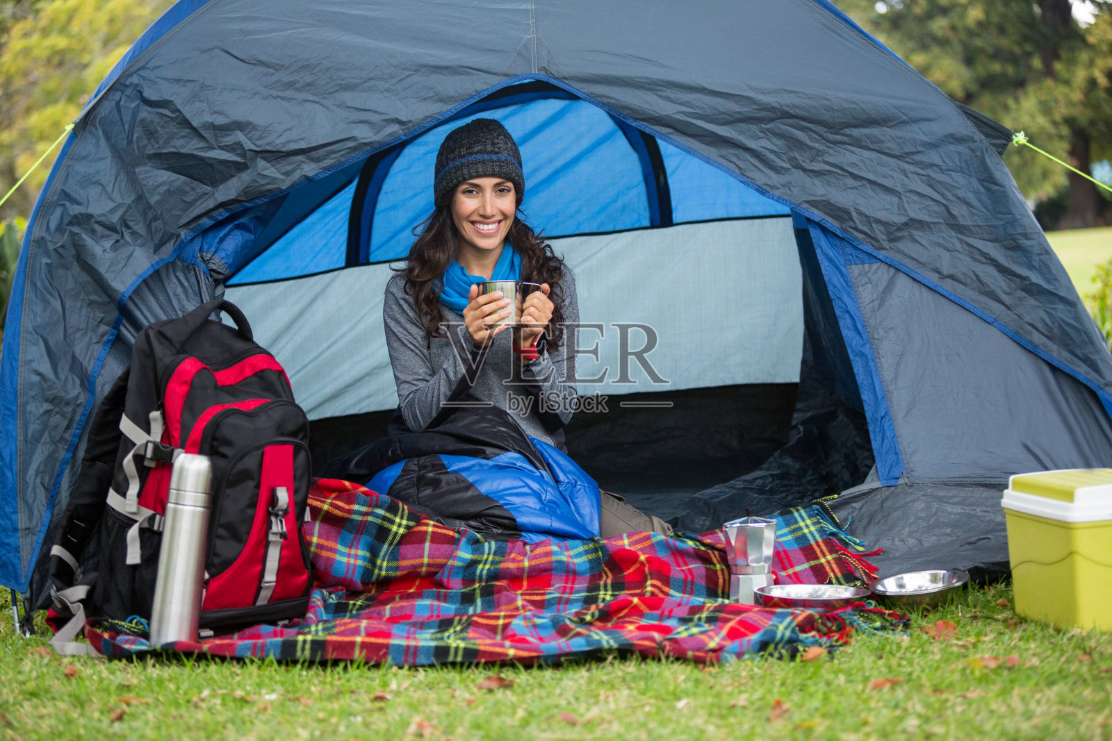肖像微笑的徒步旅行者在帐篷里喝咖啡照片摄影图片