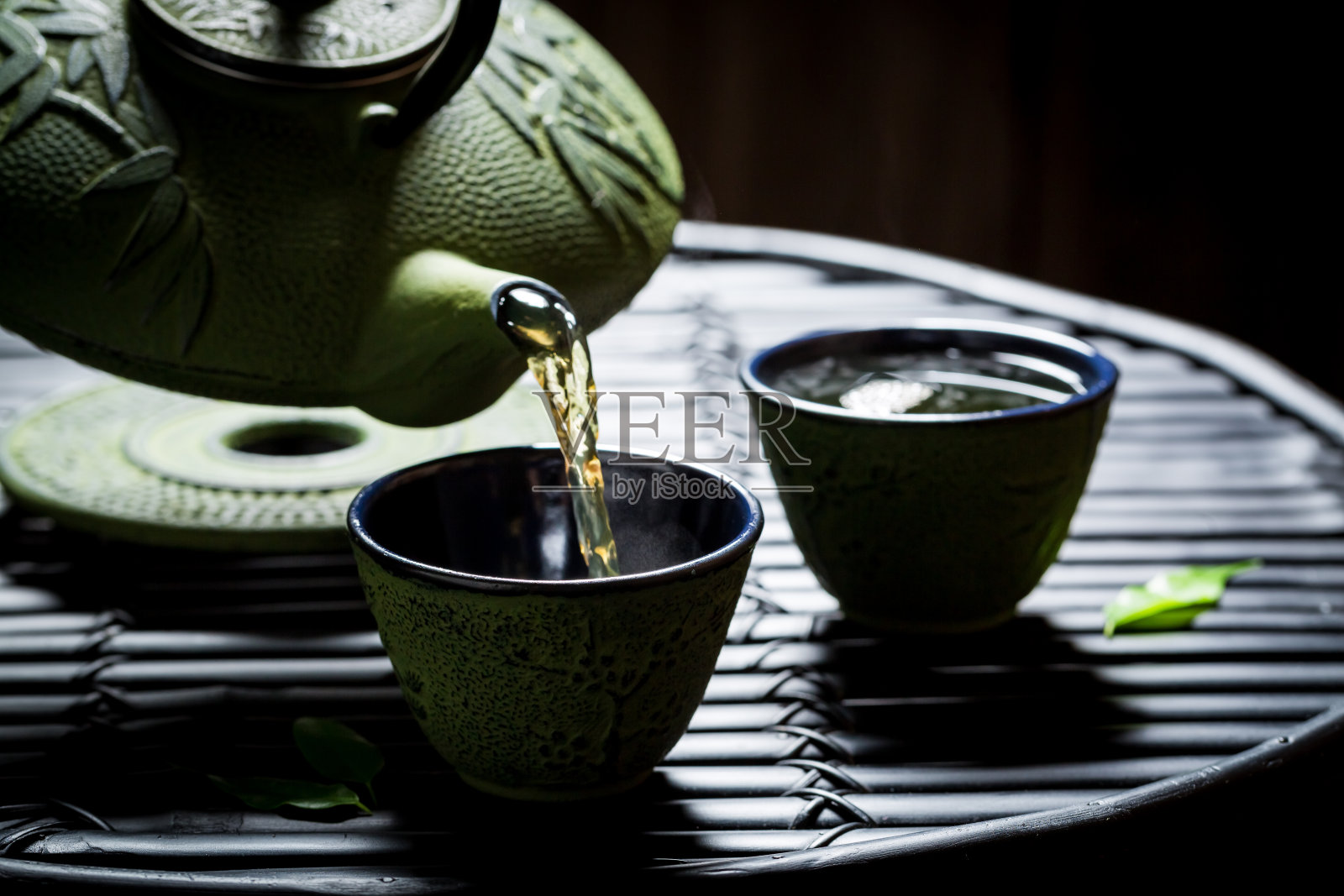 香喷喷的凉茶，茶壶放在黑色的桌子上照片摄影图片