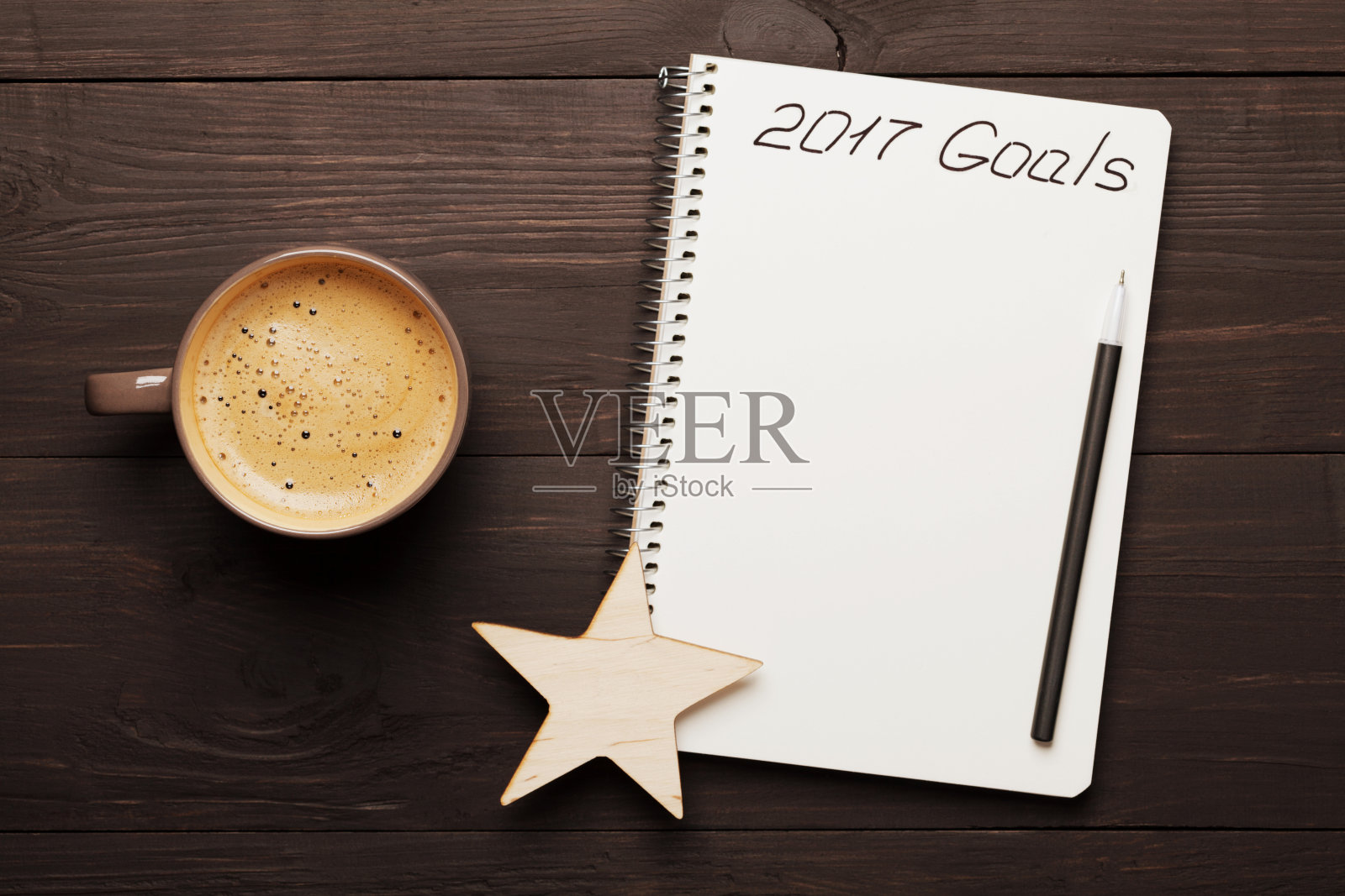 咖啡和笔记本上写着2017年的目标。规划和动机。照片摄影图片