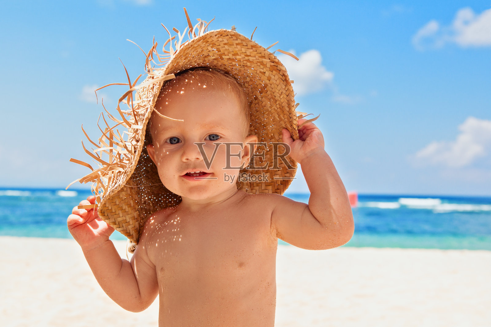 快乐的孩子与稻草在海滩上的家庭度假照片摄影图片