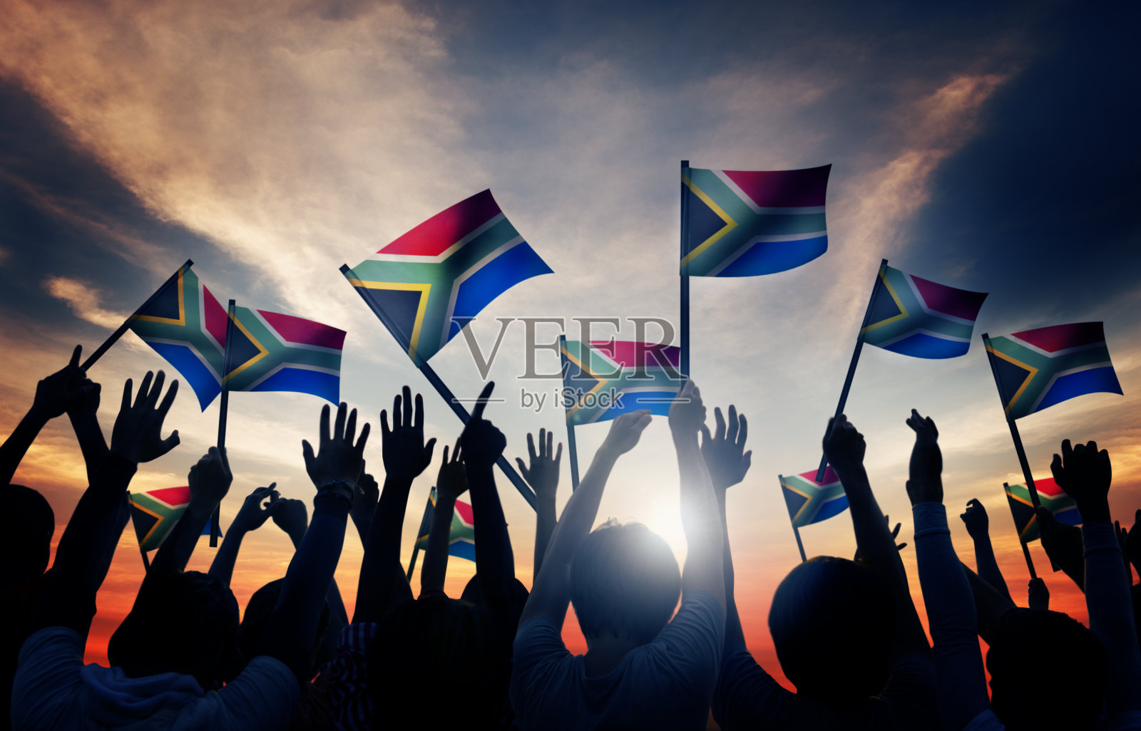 一群人在背光中挥舞着南非国旗照片摄影图片