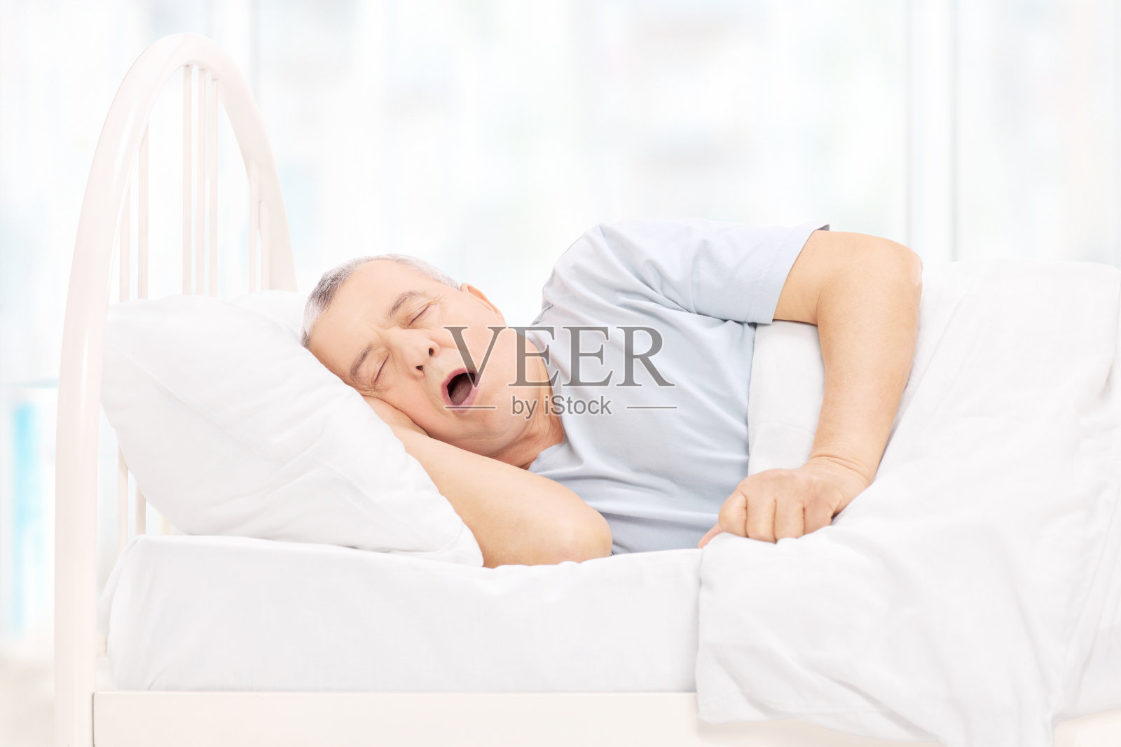 成熟的男人睡在舒适的床上照片摄影图片