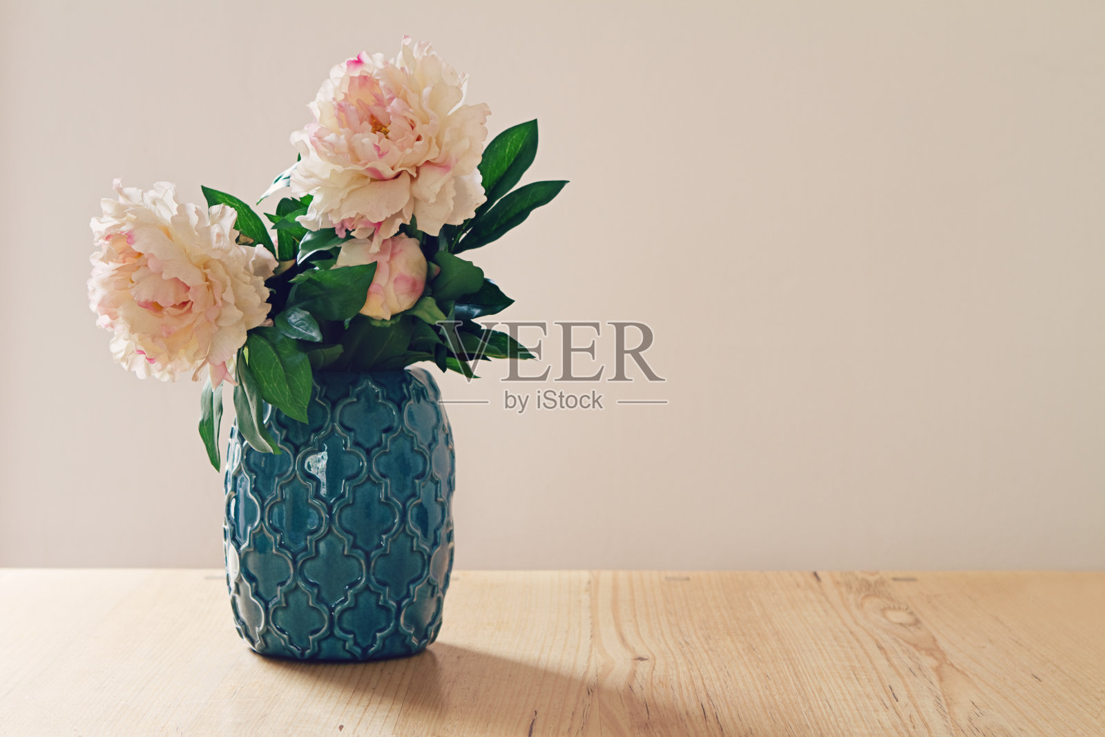 蓝色摩洛哥风格的花瓶，大的白色和粉红色的花照片摄影图片