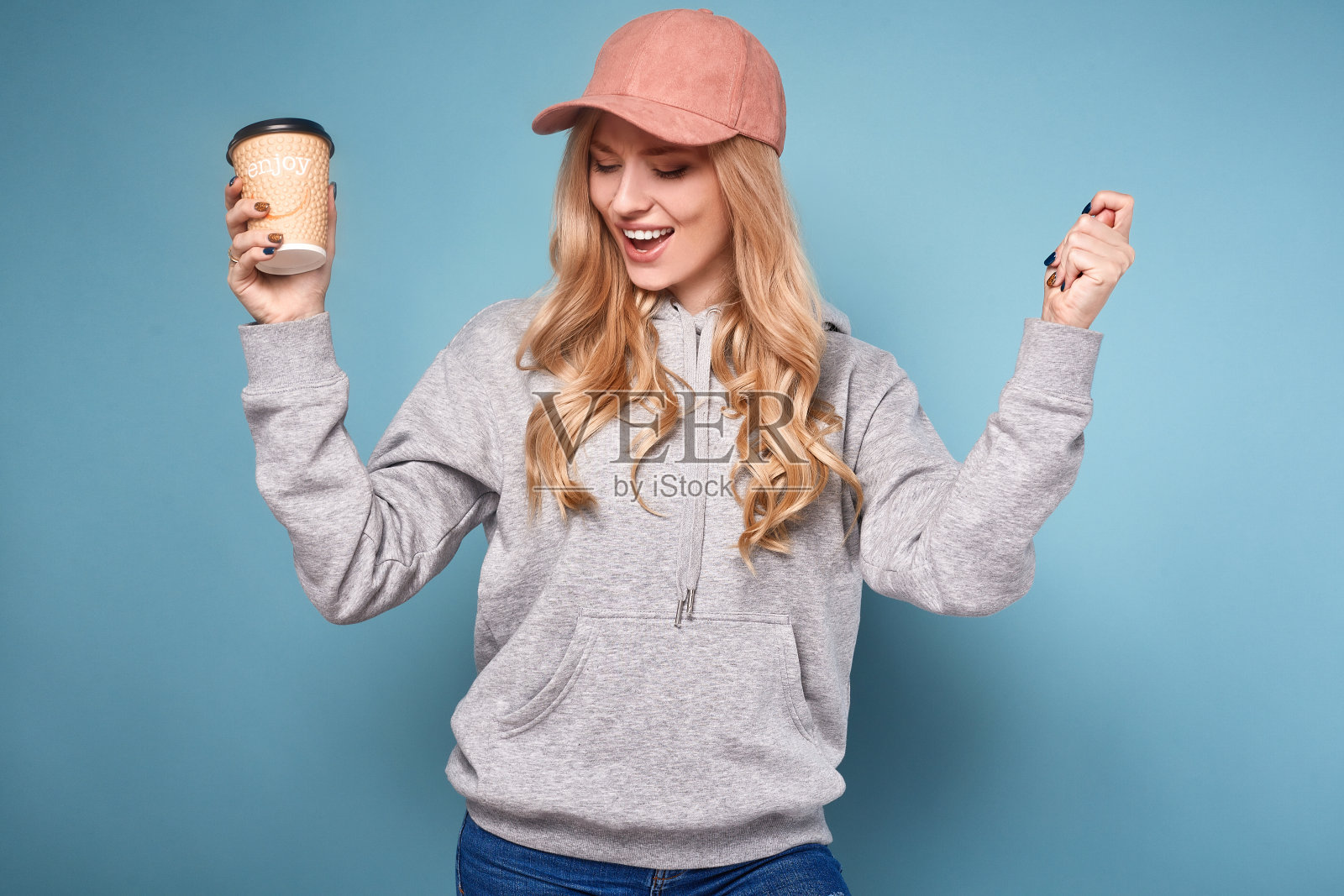 可爱的金发女人在粉红色的帽子和咖啡照片摄影图片