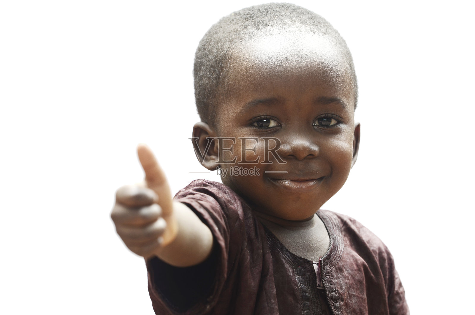 在孤立的白色背景下，一个非洲小男孩在户外展示他的拇指照片摄影图片
