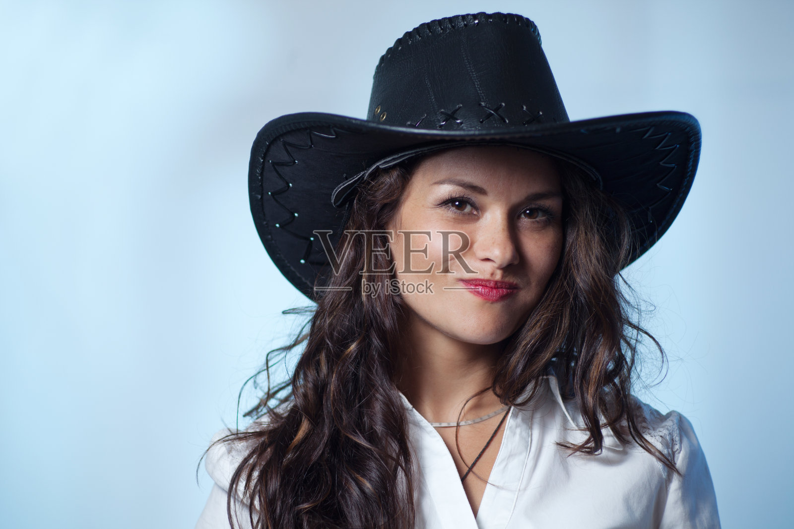 一个戴着帽子的性感美丽的女牛仔照片摄影图片