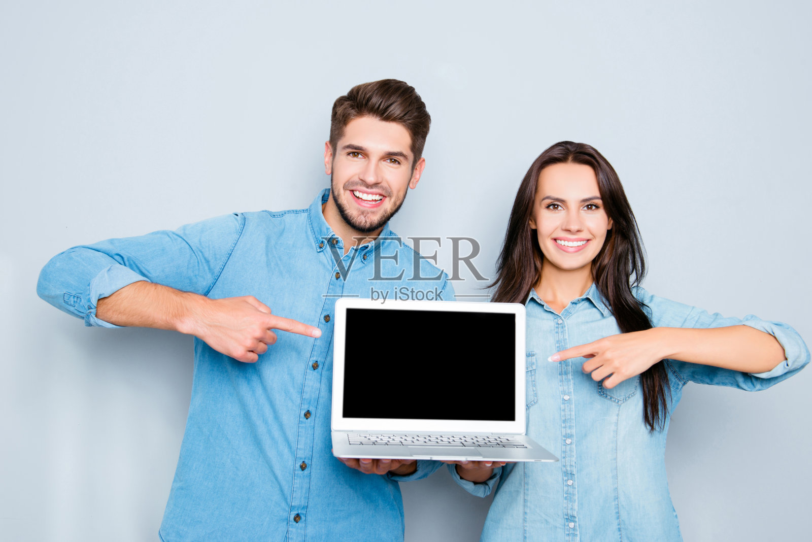 幸福的夫妇显示笔记本电脑和指向黑屏照片摄影图片