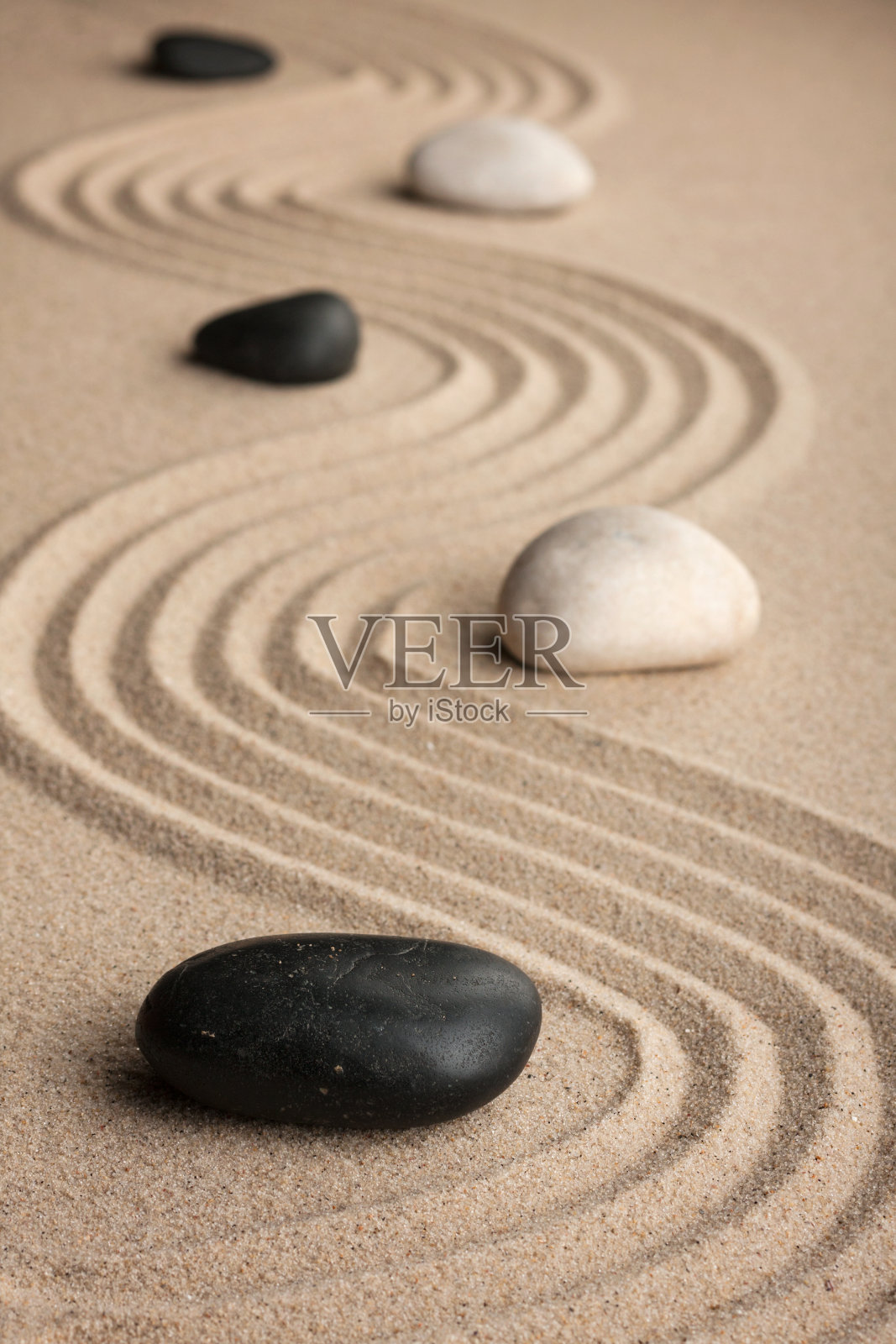 沙子上的石头的透视。照片摄影图片
