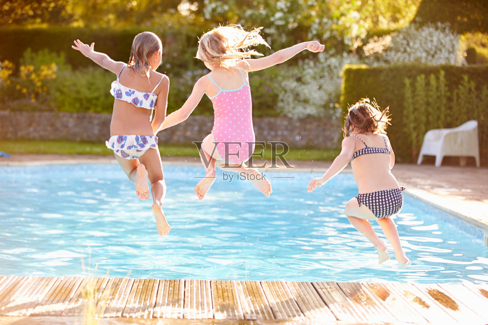 一群女孩跳进室外游泳池照片摄影图片