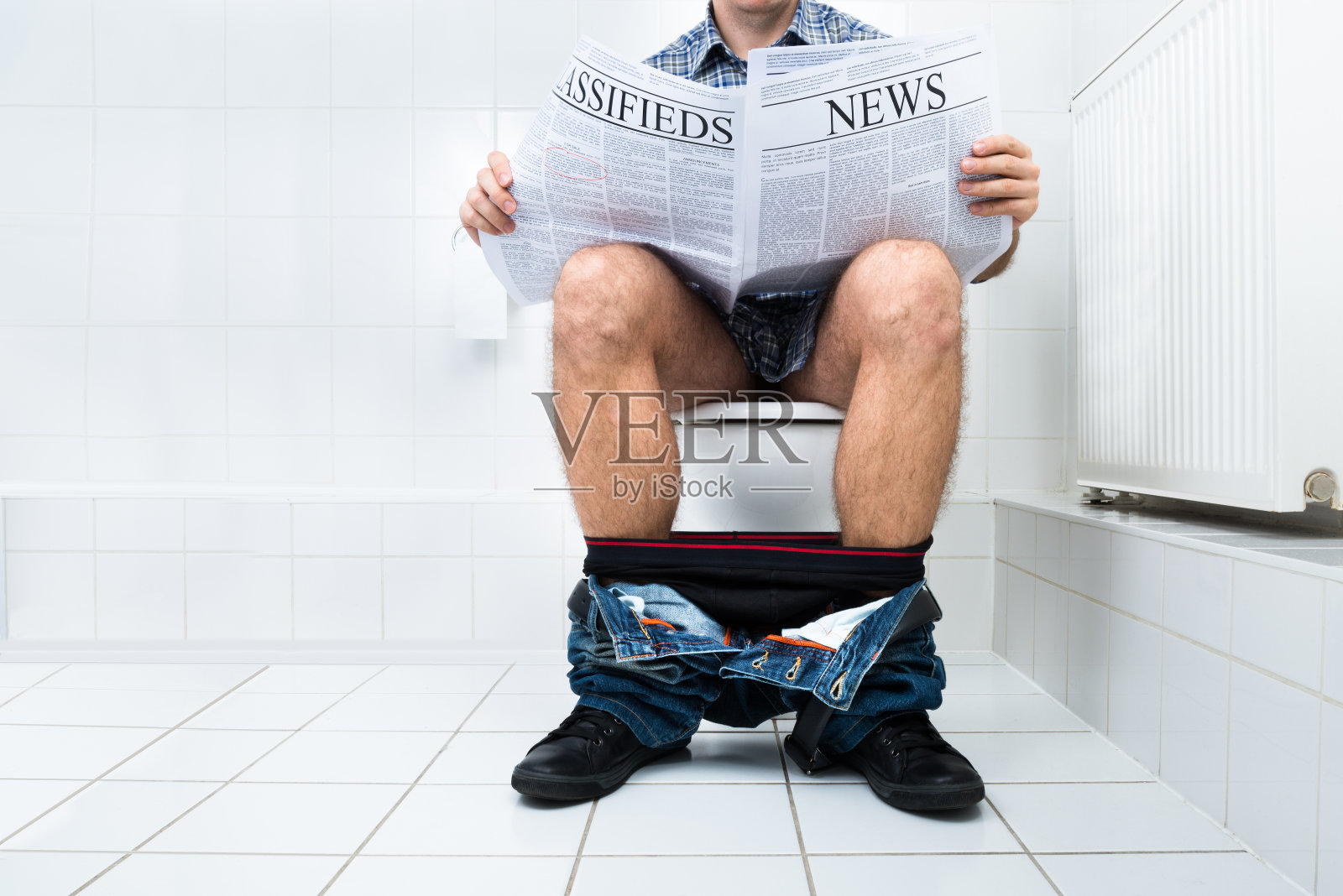 在厕所看报纸的男人照片摄影图片
