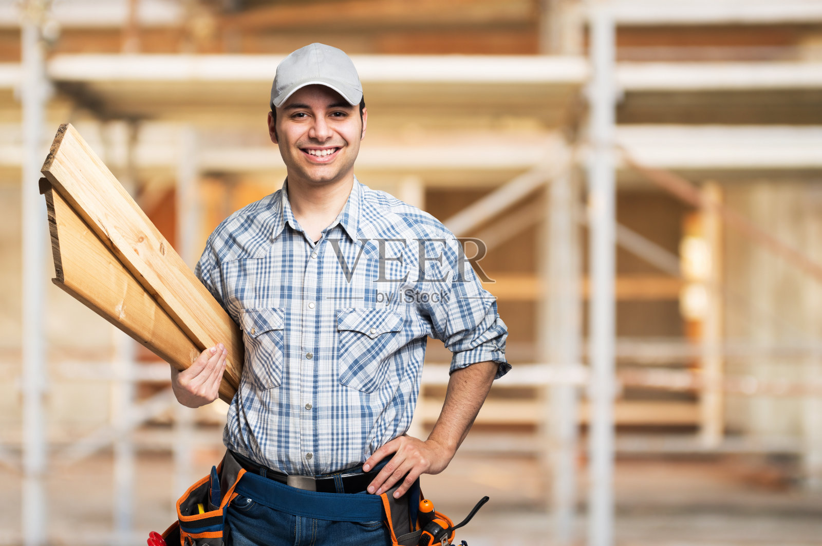 一个微笑的木匠在建筑工地的肖像照片摄影图片