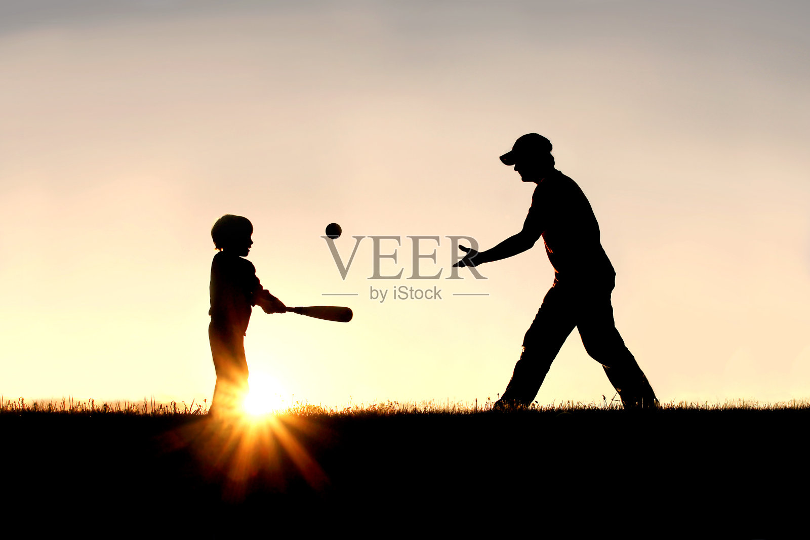 父亲和儿子在外面打棒球的剪影照片摄影图片