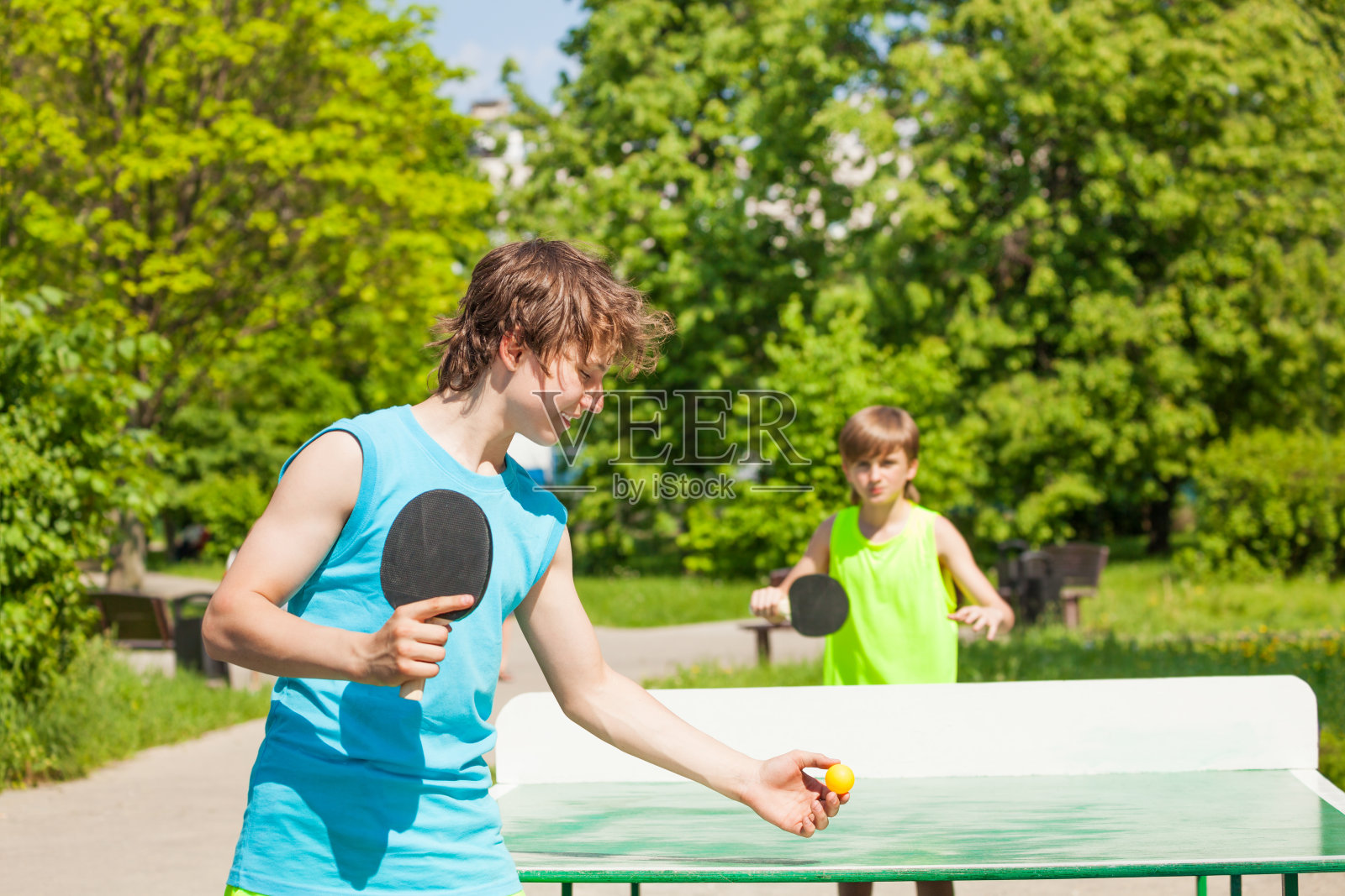 两个男孩在外面一起打乒乓球照片摄影图片