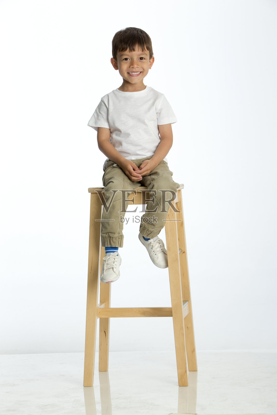 小男孩坐在高凳子上照片摄影图片