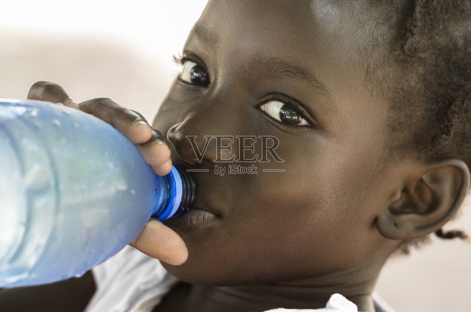 贫穷的象征:非洲黑人女孩饮用健康的淡水照片摄影图片