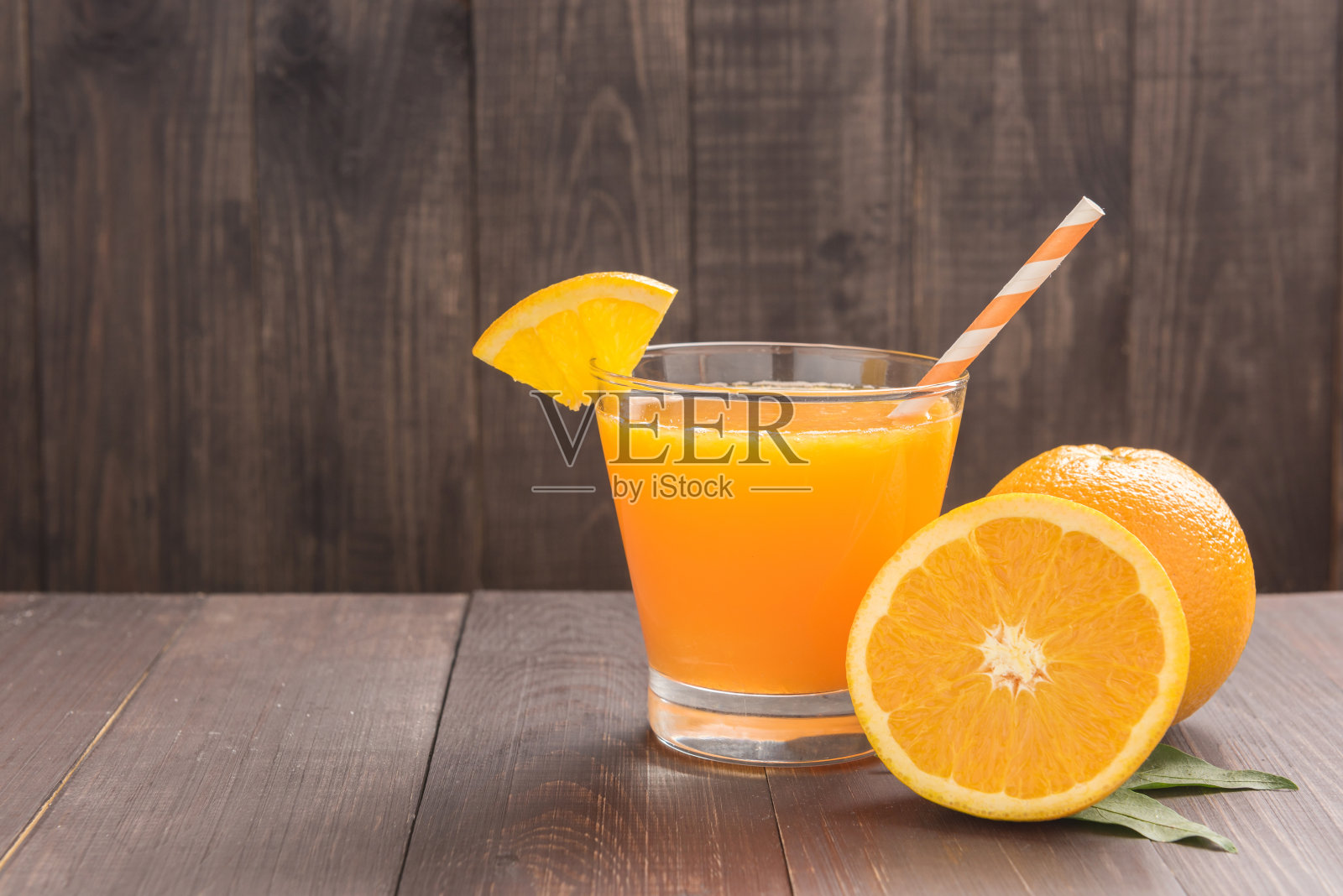 新鲜的橙汁和橘子放在木桌上照片摄影图片