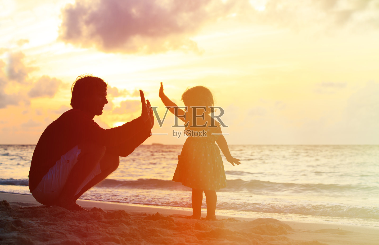 父亲和小女儿在日落时玩剪影照片摄影图片