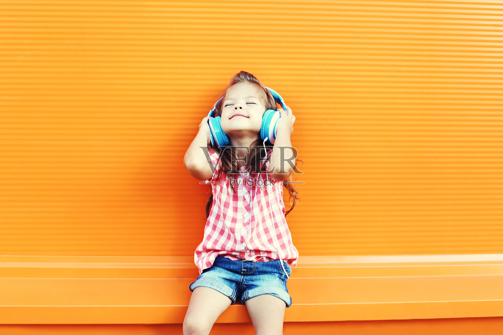 快乐的孩子喜欢戴着耳机听音乐照片摄影图片