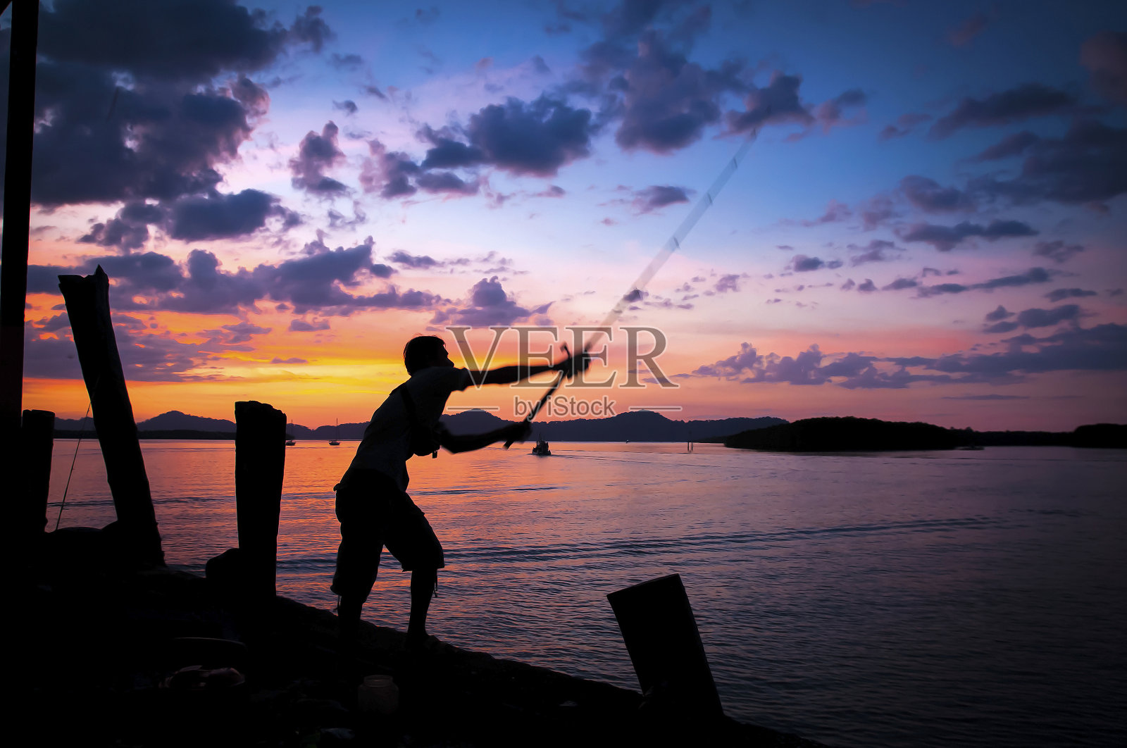 一名男子在泰国的一个码头钓鱼照片摄影图片
