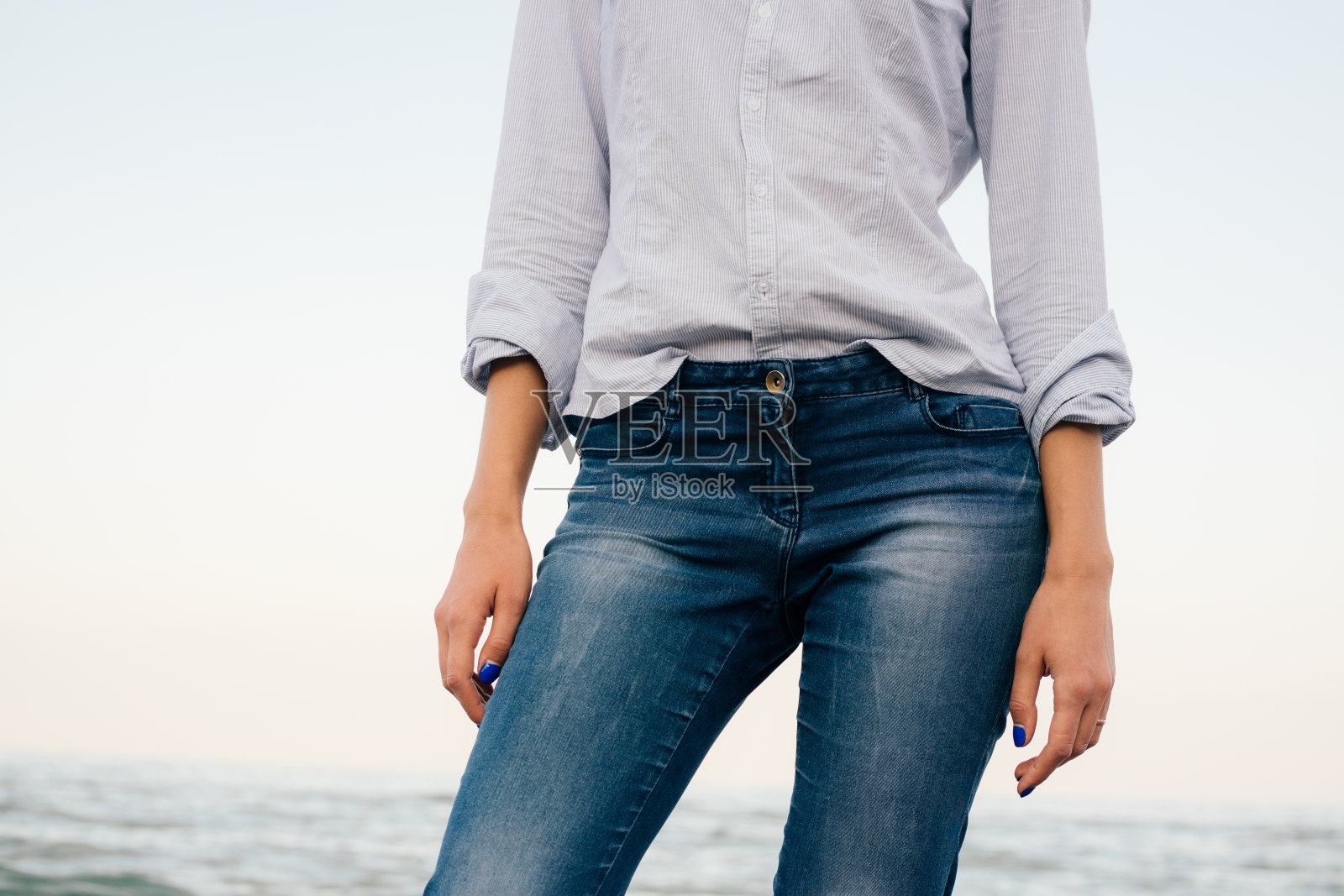 穿条纹衬衫和蓝色牛仔裤的女人照片摄影图片