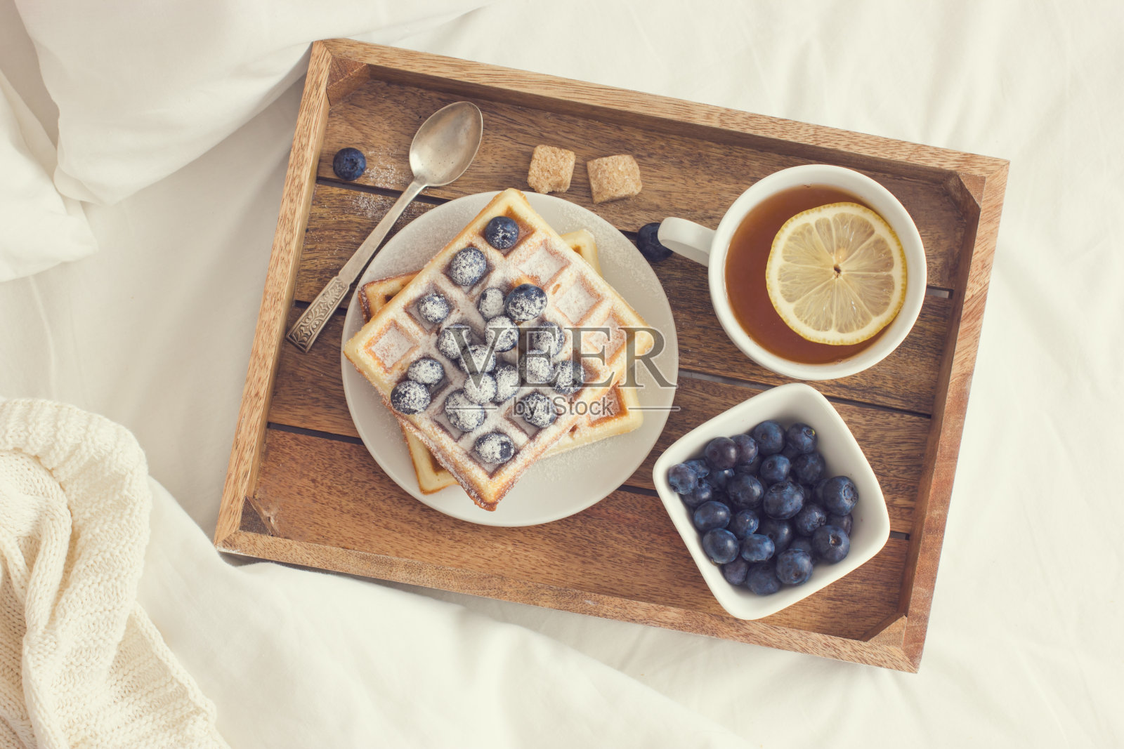 早餐在床上，托盘上有比利时蓝莓华夫饼照片摄影图片