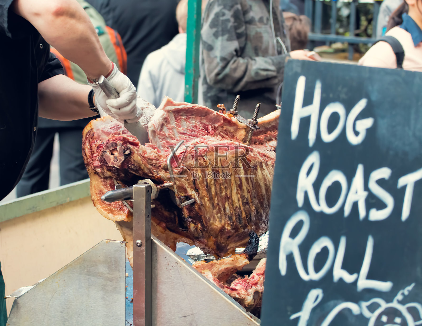 烤猪街头食品市场小贩。雕刻烤猪照片摄影图片