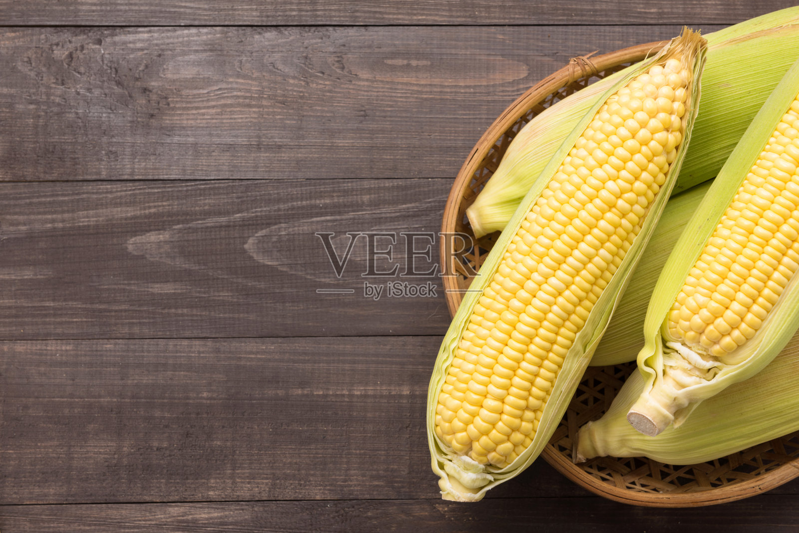 新鲜的有机黄色甜玉米放在木桌上。俯视图照片摄影图片