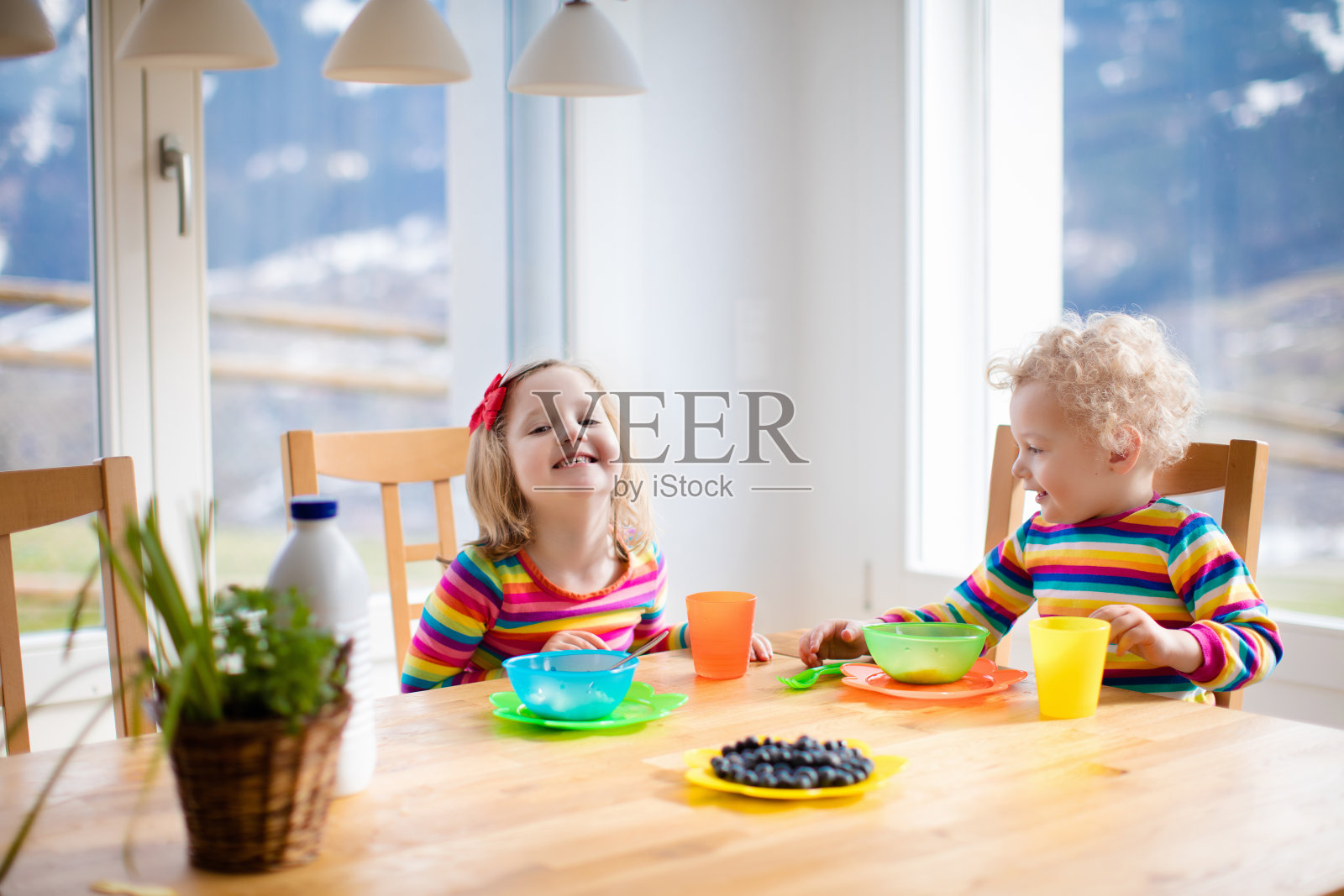 孩子们在阳光明媚的厨房里吃早餐照片摄影图片
