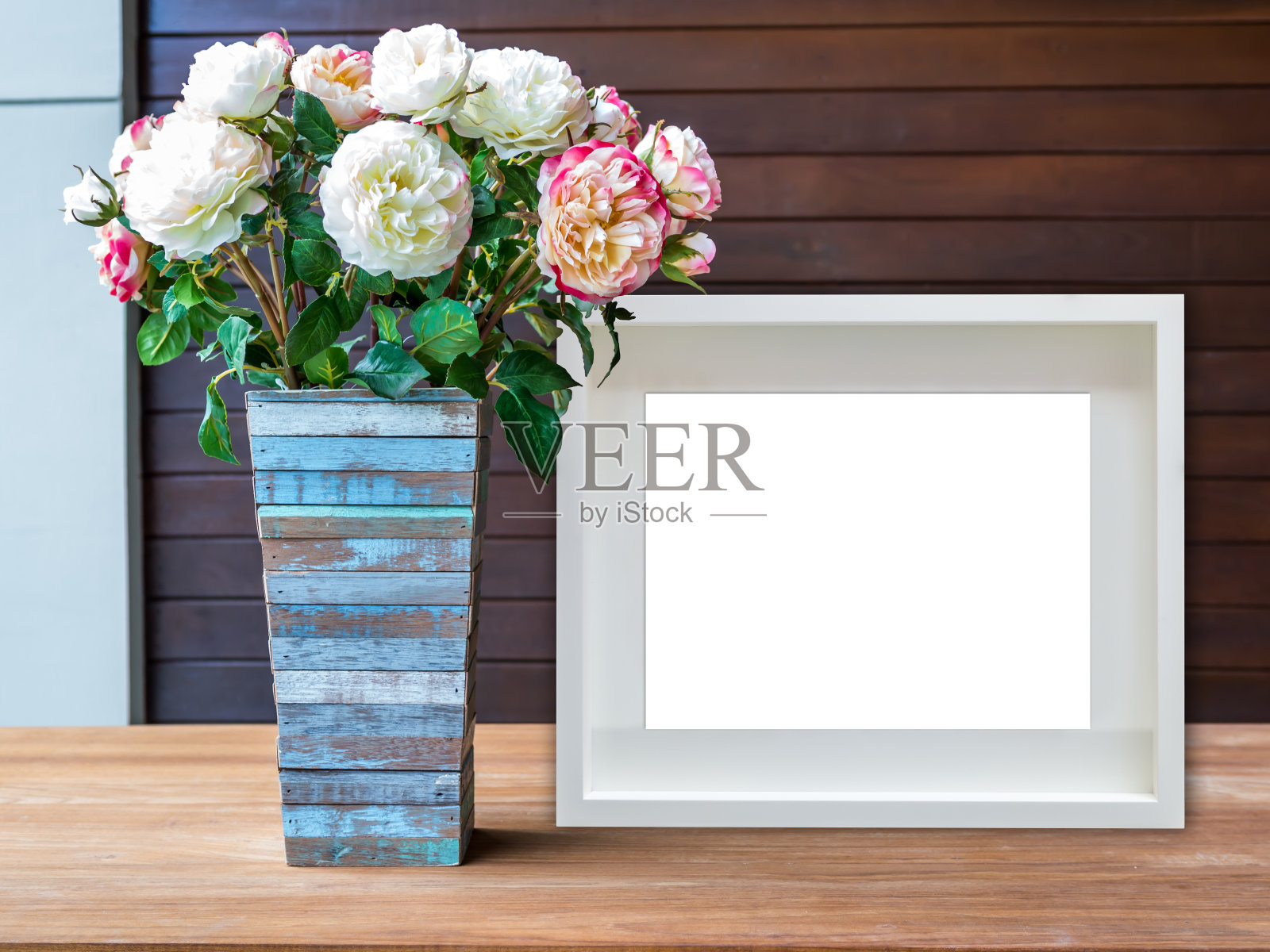 木桌上的空白白色画框和花瓶照片摄影图片