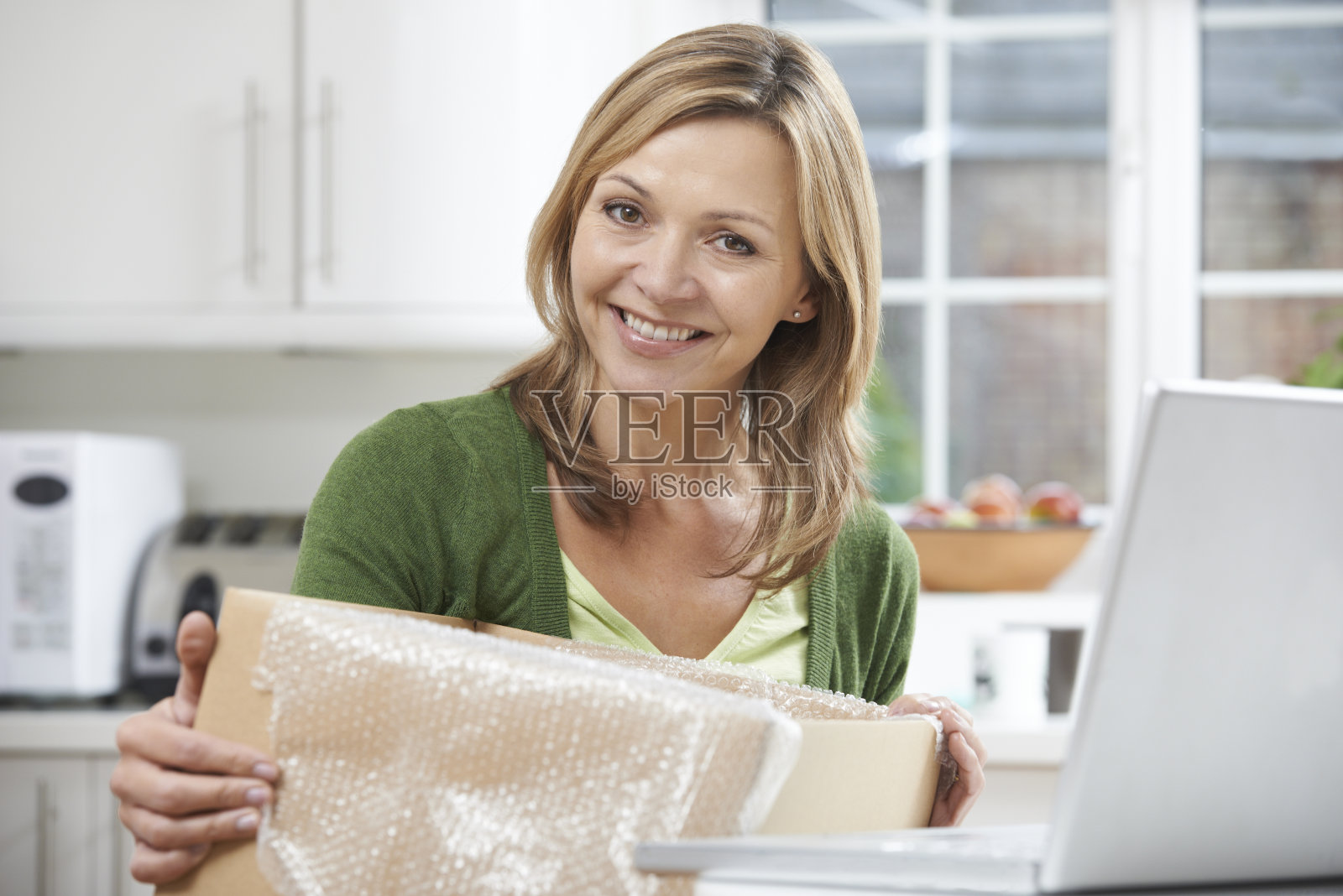 快乐的女人在家里打开网上购物的包装照片摄影图片