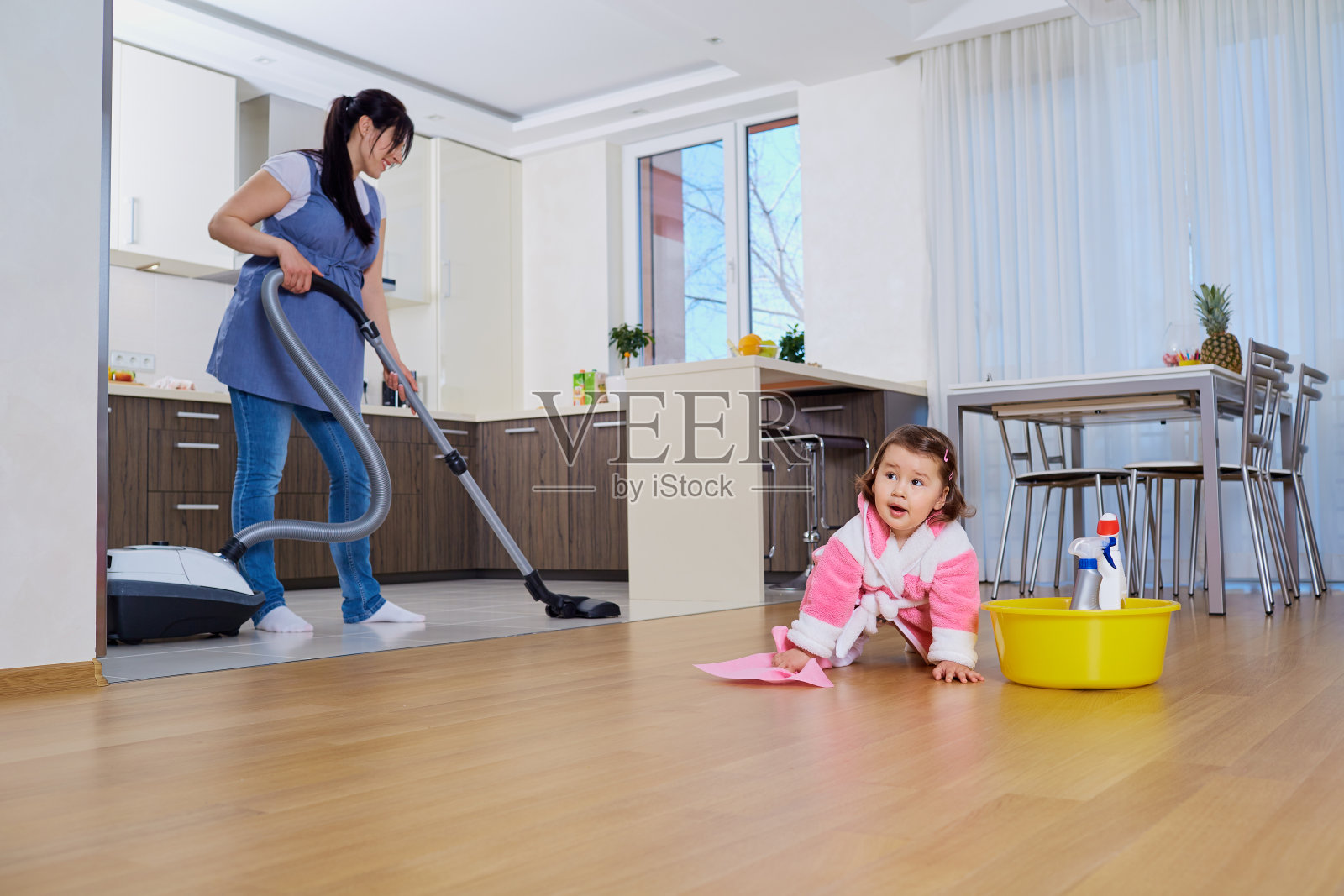 母亲和孩子打扫房间。照片摄影图片