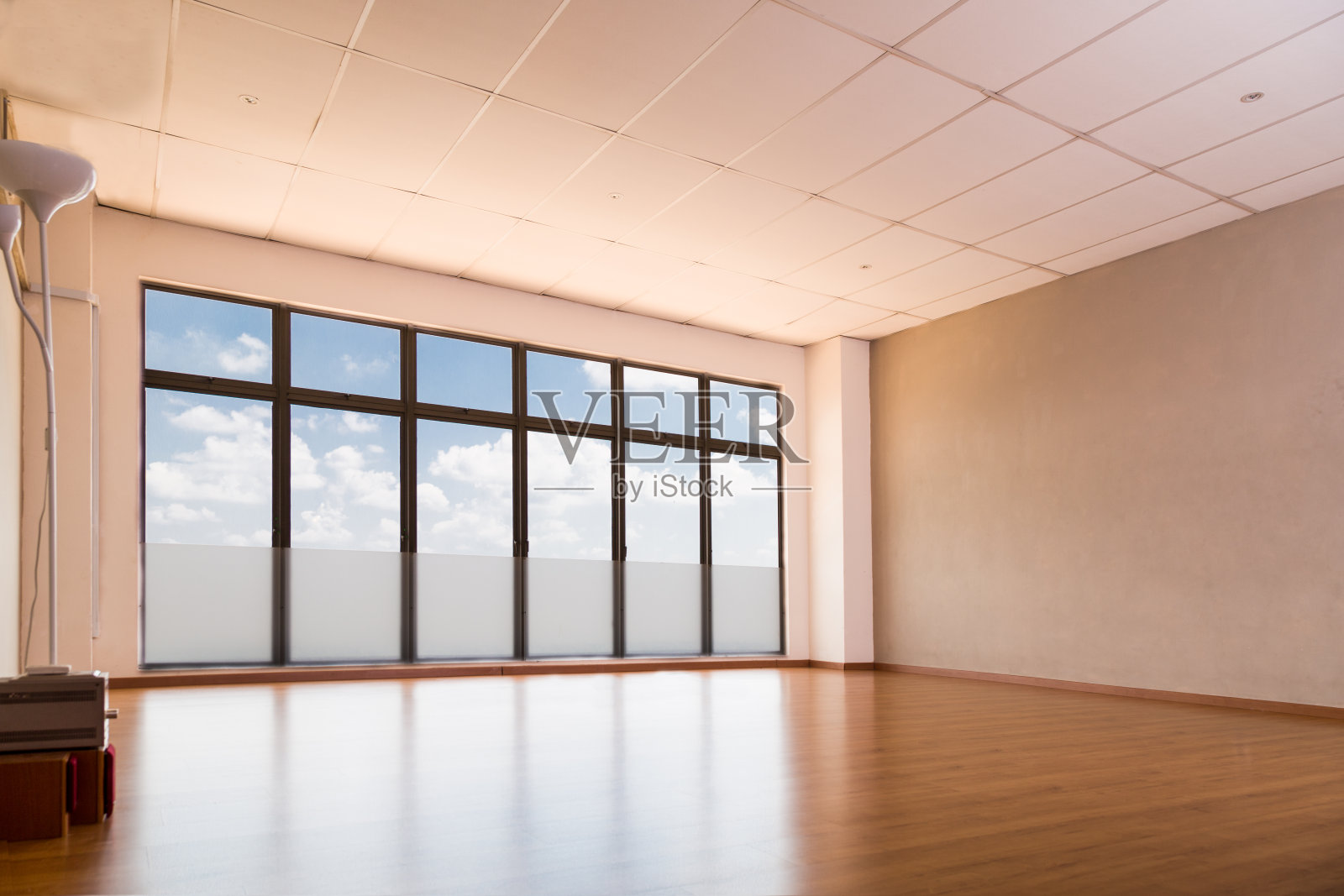 空荡荡的瑜伽室，铺着木地板，窗户上是蓝天照片摄影图片