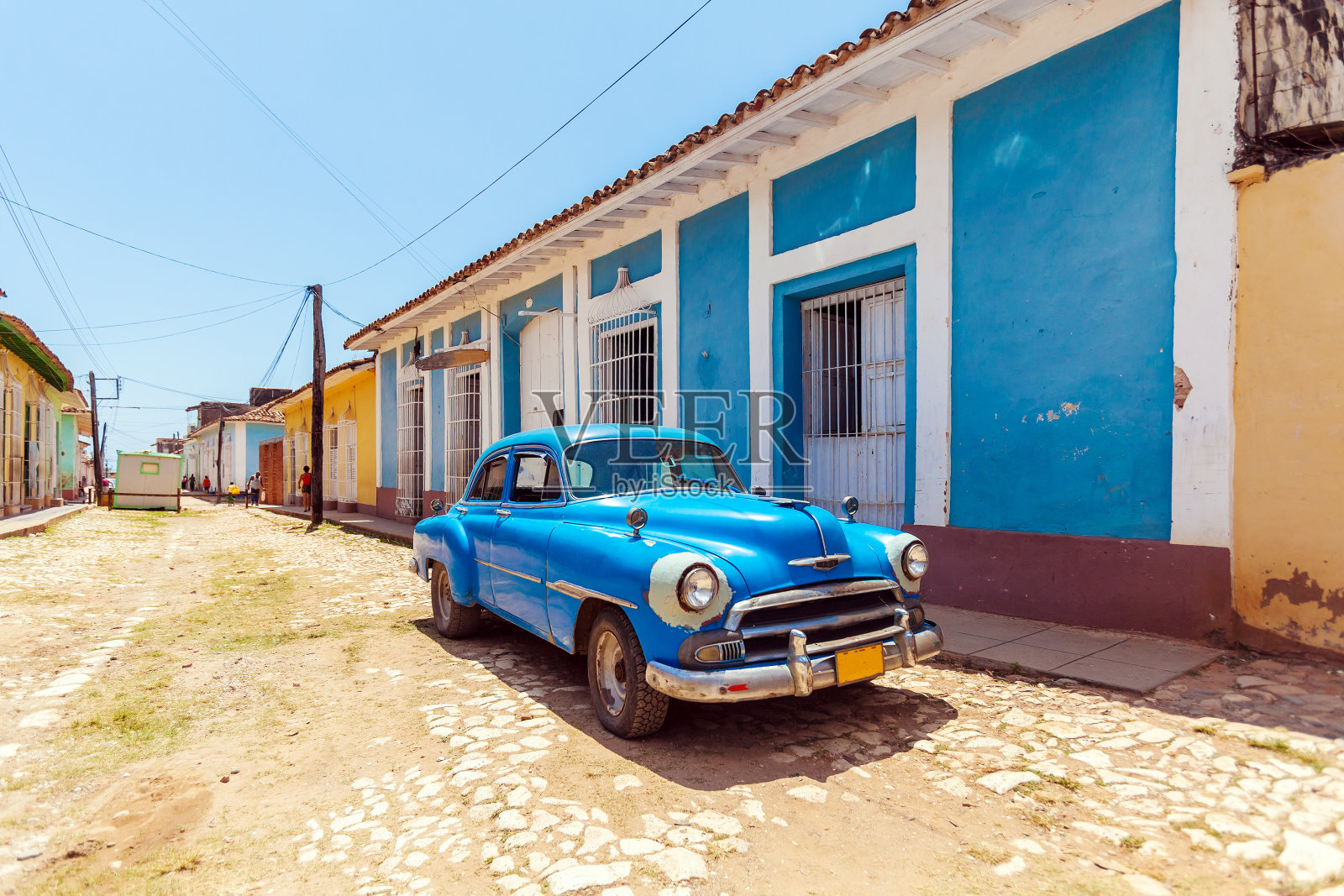 特立尼达老城房子附近的老式蓝色汽车照片摄影图片