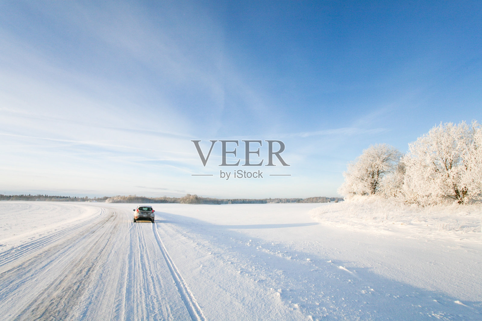 一辆小汽车在冬天的雪地上行驶照片摄影图片