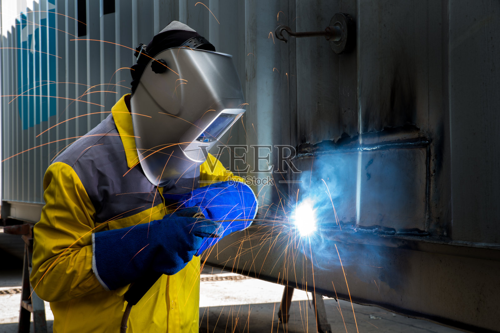 工业工人用焊接钢来修理集装箱照片摄影图片