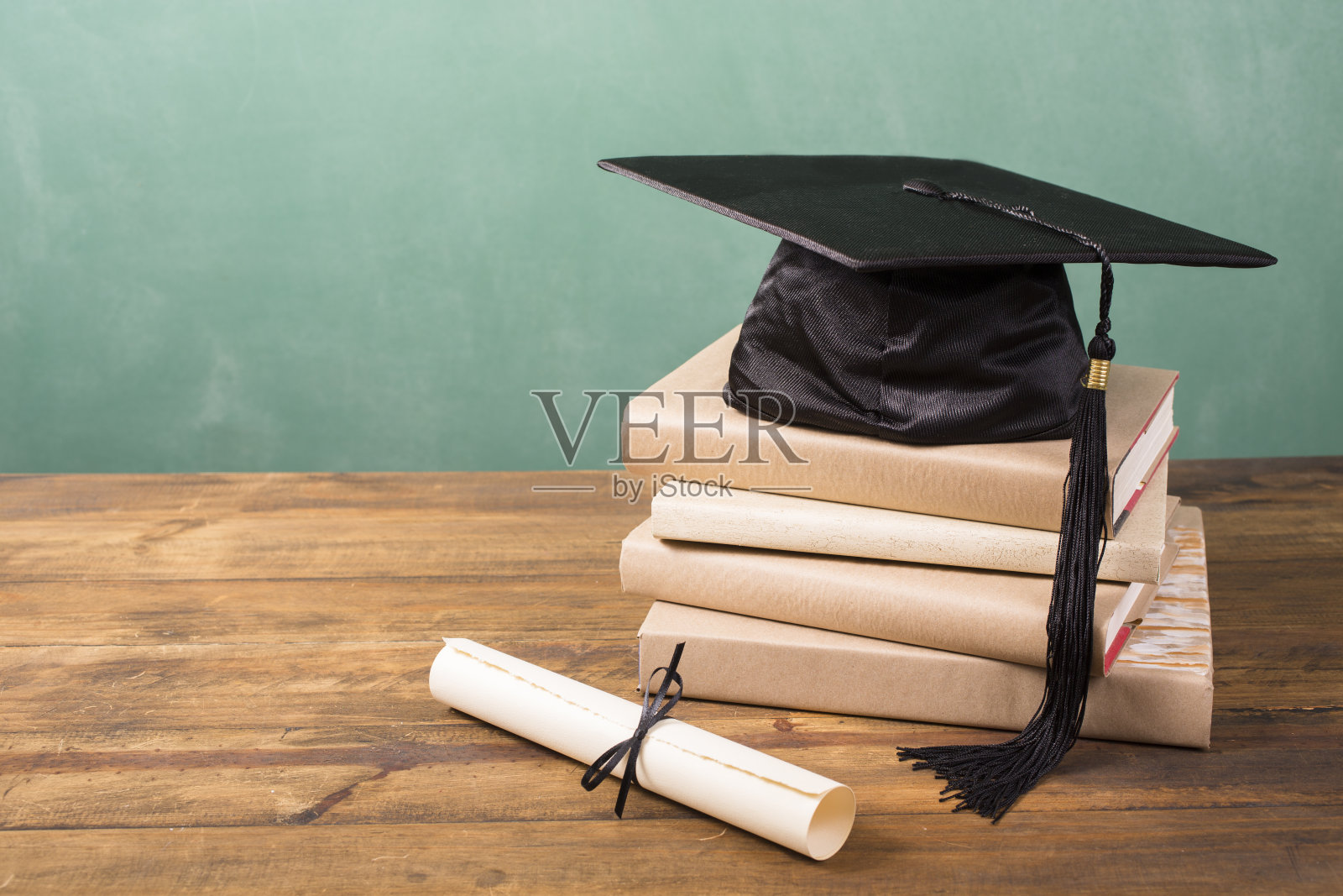 毕业!学士帽，学士帽和流苏，学位证书摆在桌上。教育。照片摄影图片