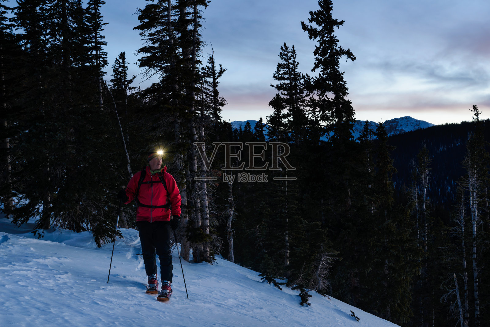 人滑雪旅行在黄昏与头灯照片摄影图片