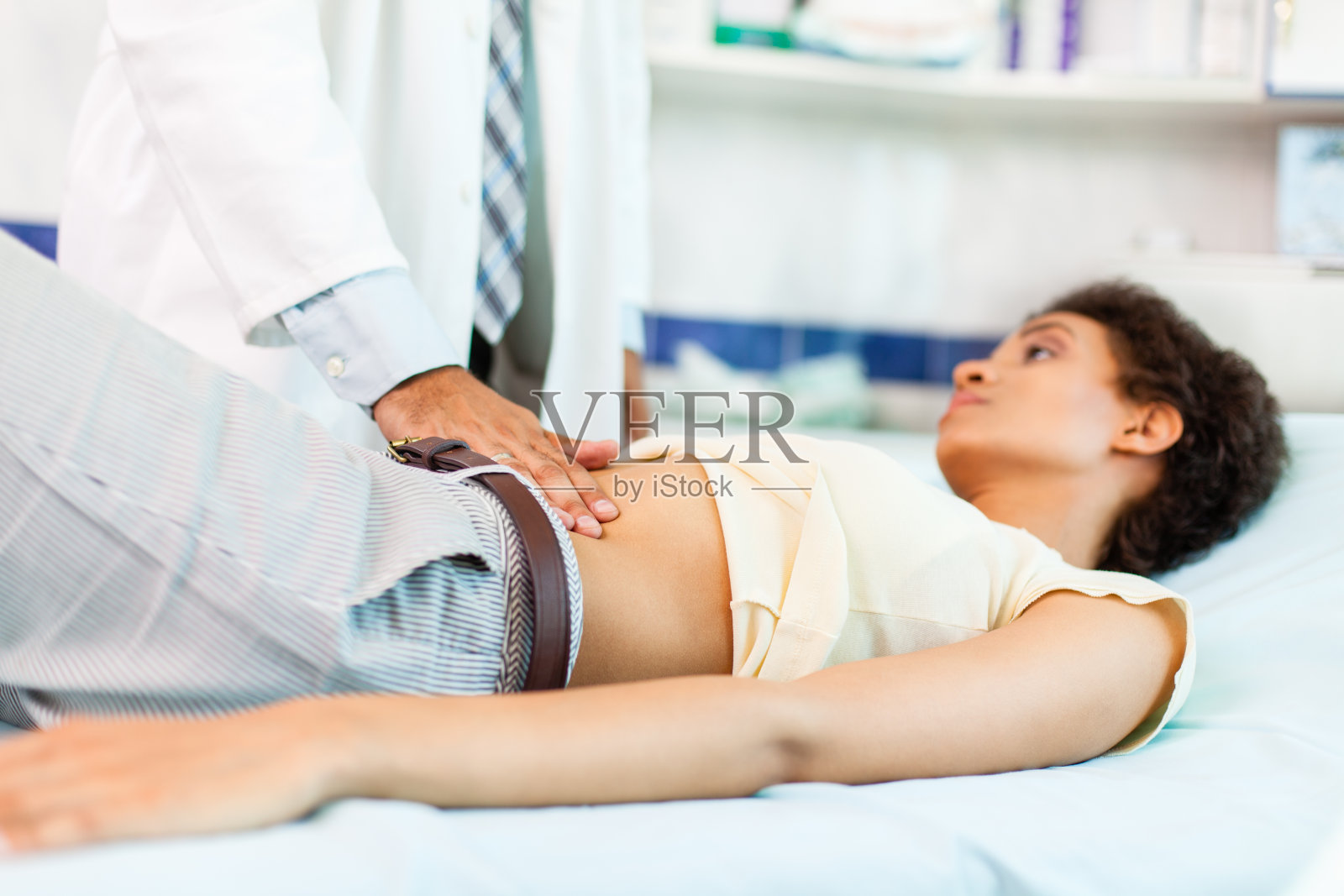 妇女胃痛正在接受体检照片摄影图片