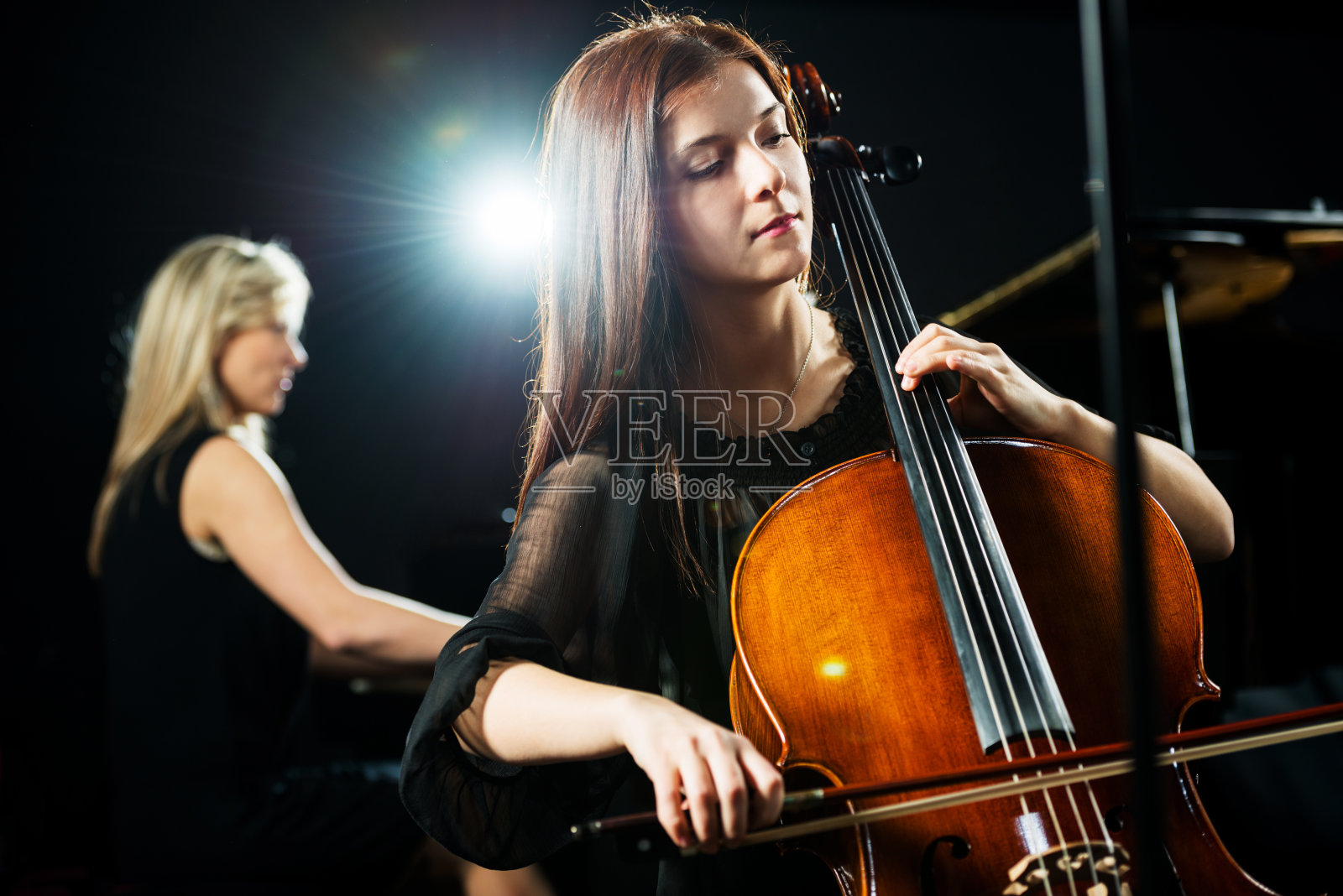 女人演奏大提琴。照片摄影图片
