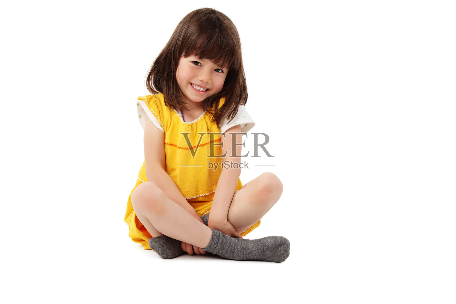 年轻女孩交叉双腿坐着-孤立照片摄影图片