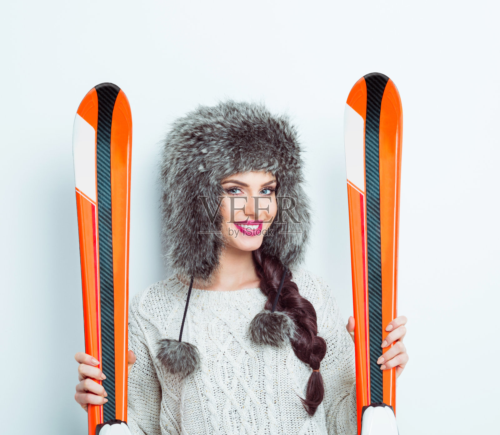 快乐的女人戴着皮帽拿着滑雪板照片摄影图片