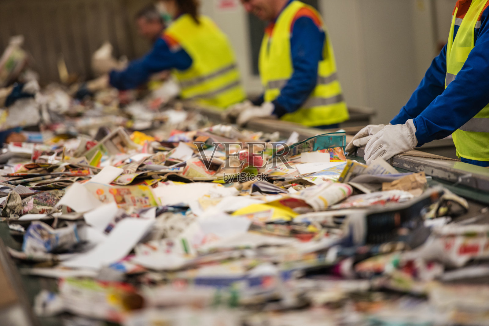 在回收厂分类废纸的工人照片摄影图片