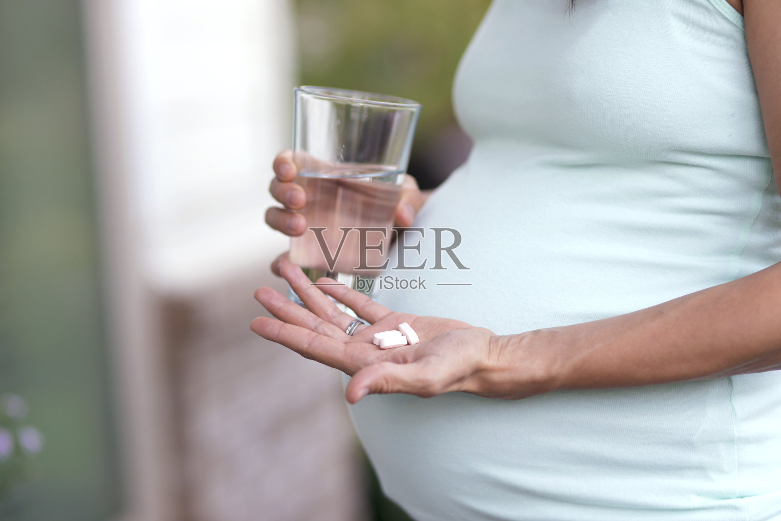 成年孕妇正要用水吞下维生素照片摄影图片